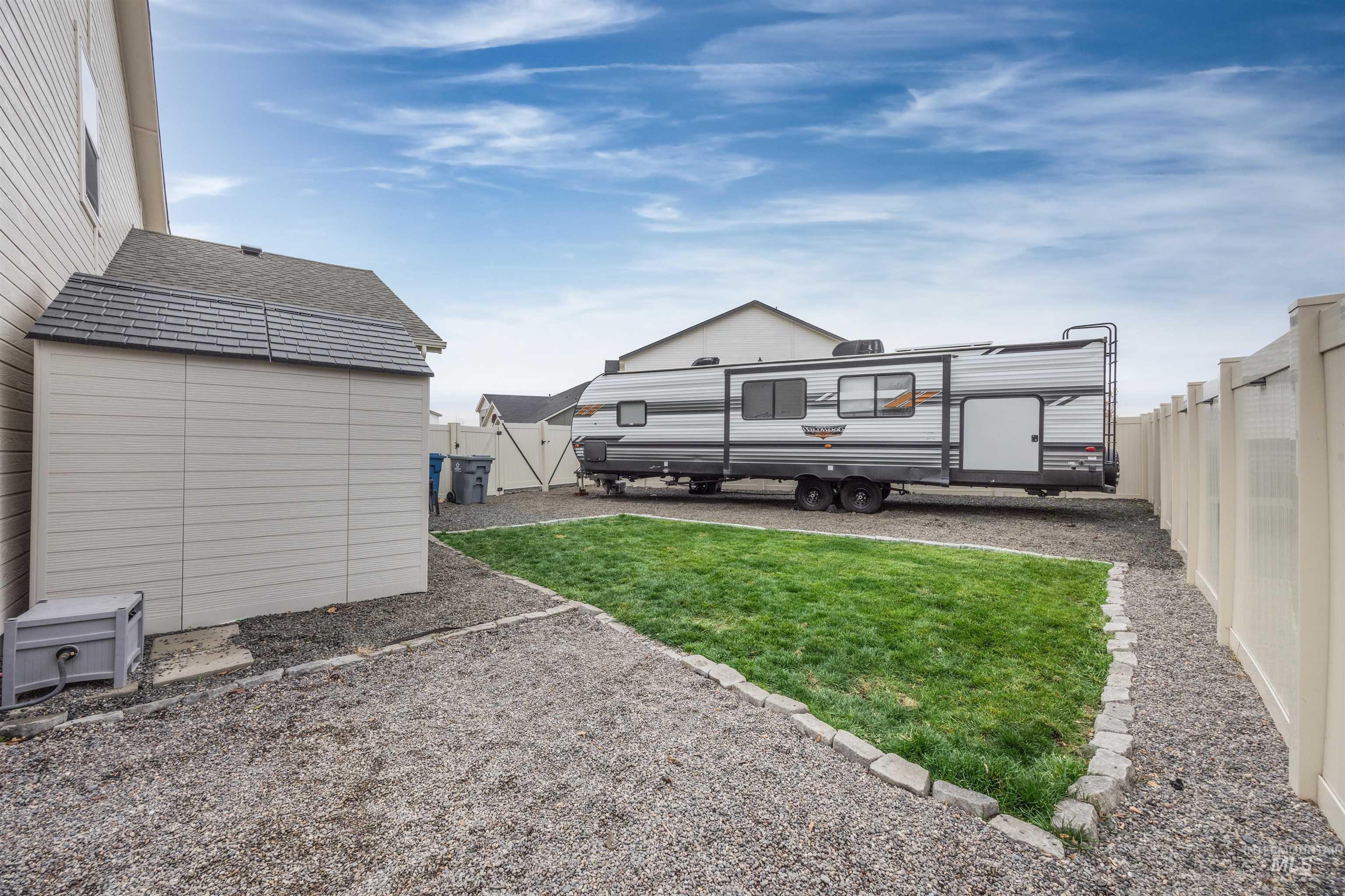 Back of property featuring a fenced backyard and a storage shed