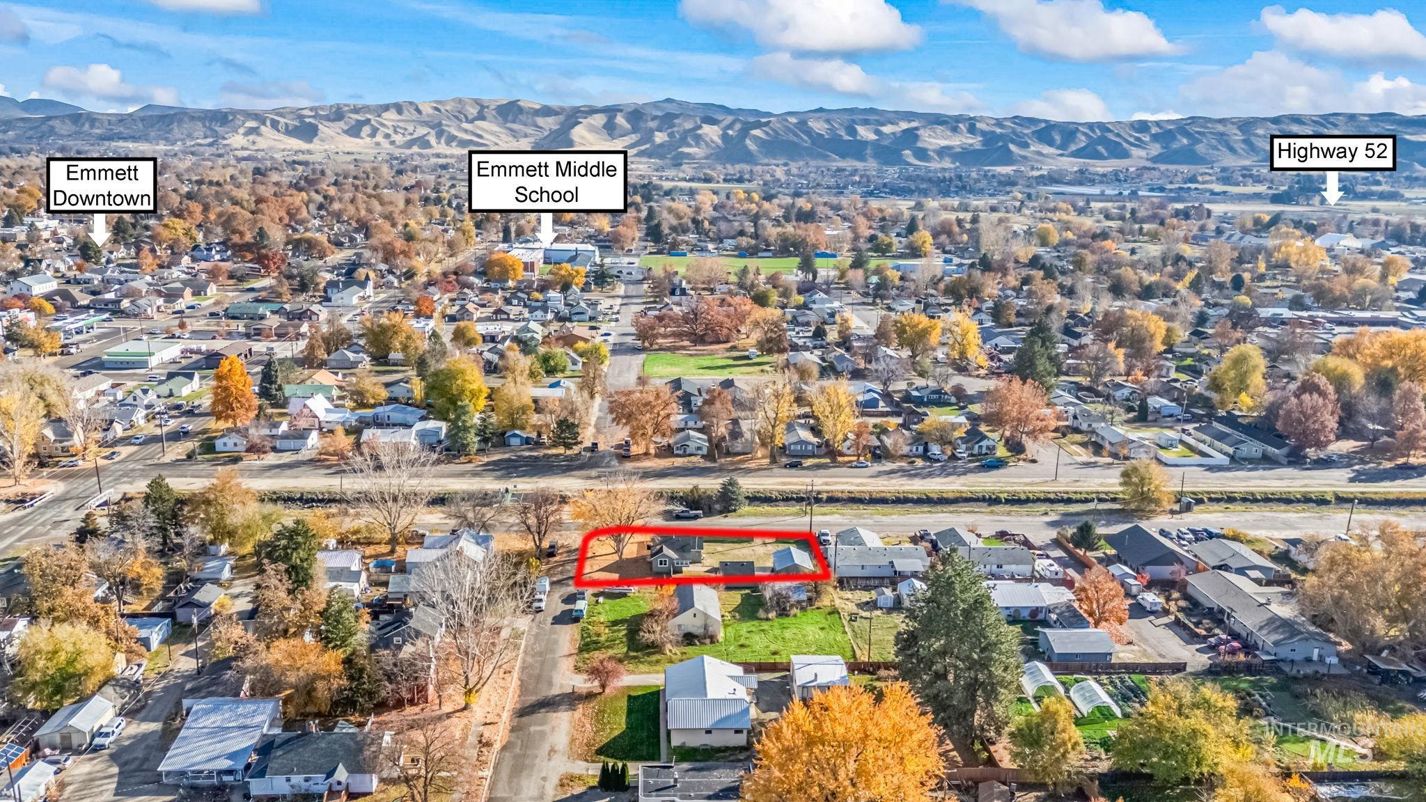Aerial view of property's location with a mountain backdrop, nearby suburban area, and property boundaries highlighted