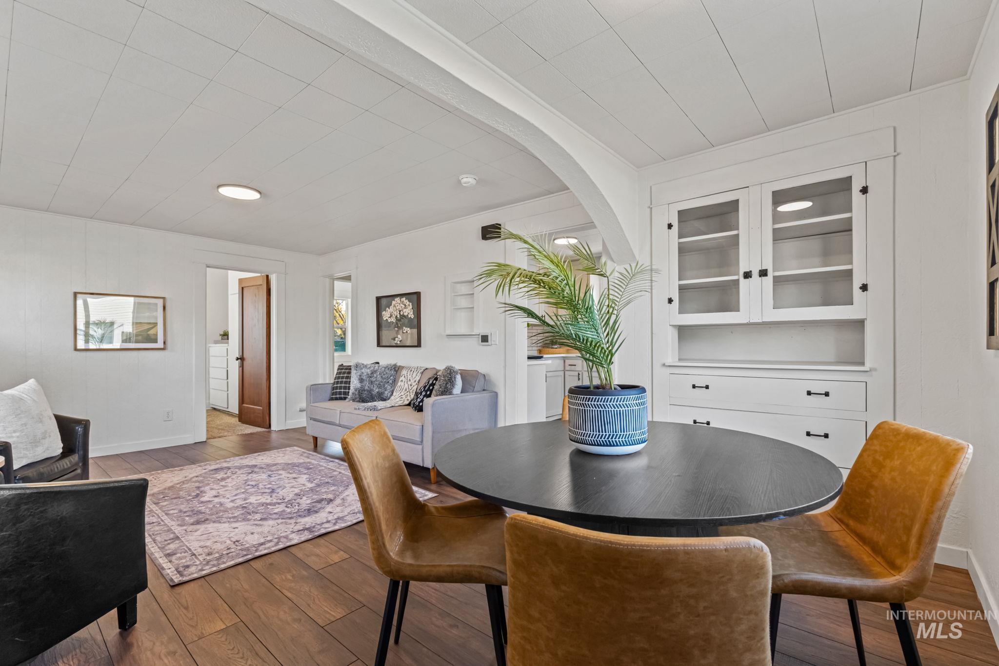 Dining area with wood-type flooring and arched walkways