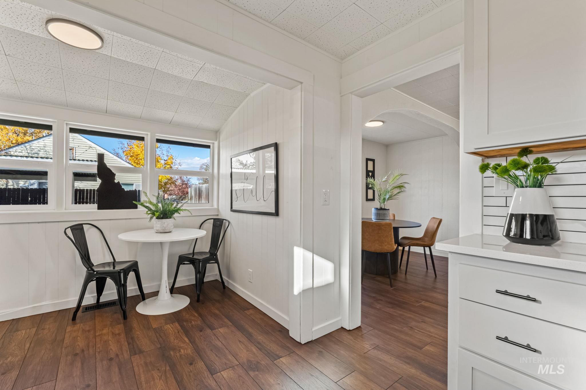 Dining area with dark wood-style flooring and arched walkways