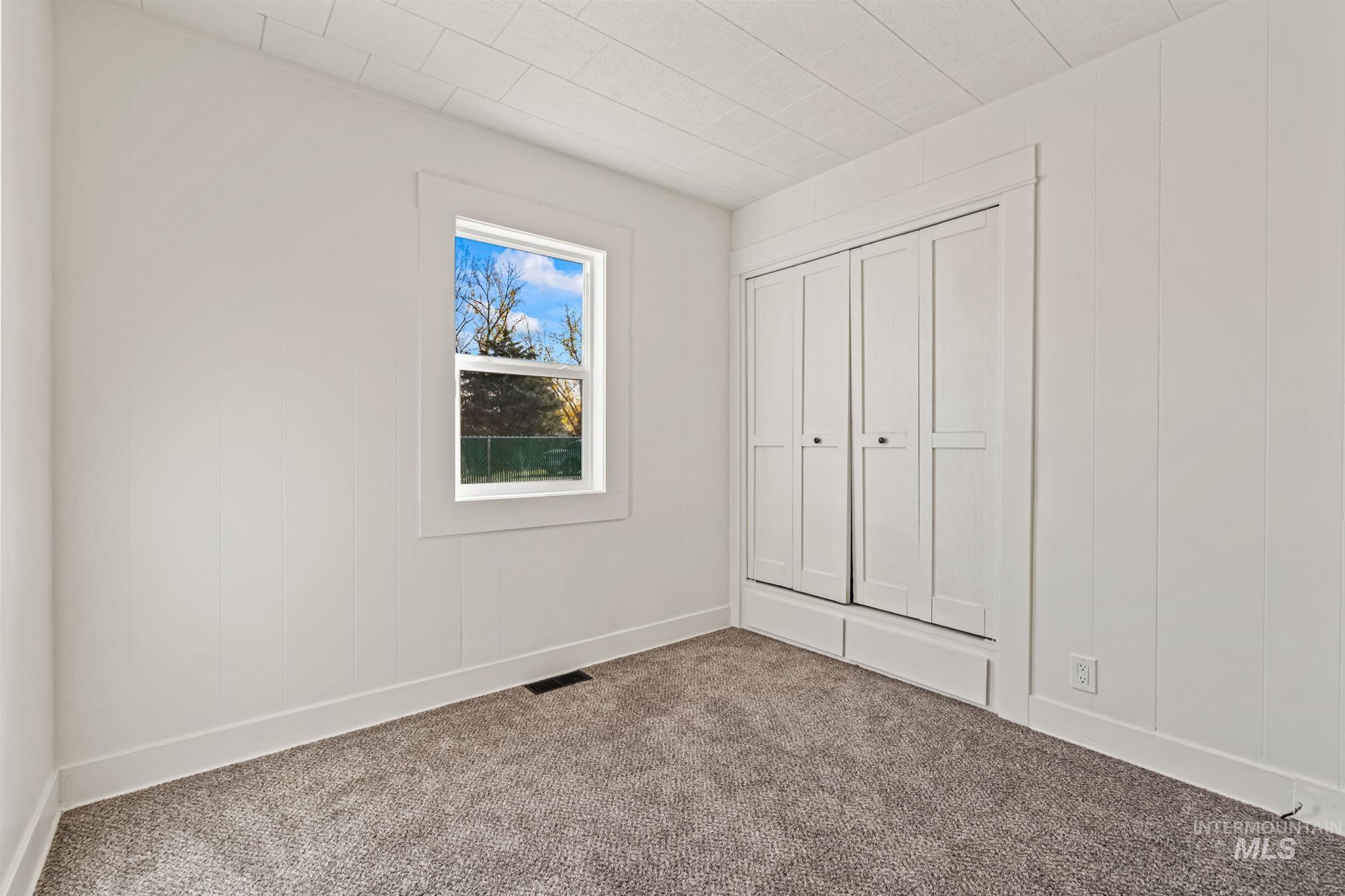 Unfurnished bedroom with carpet and a closet