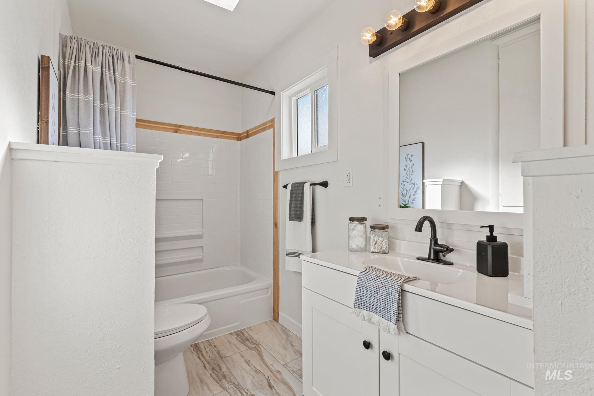 Bathroom featuring shower / bathtub combination with curtain and vanity