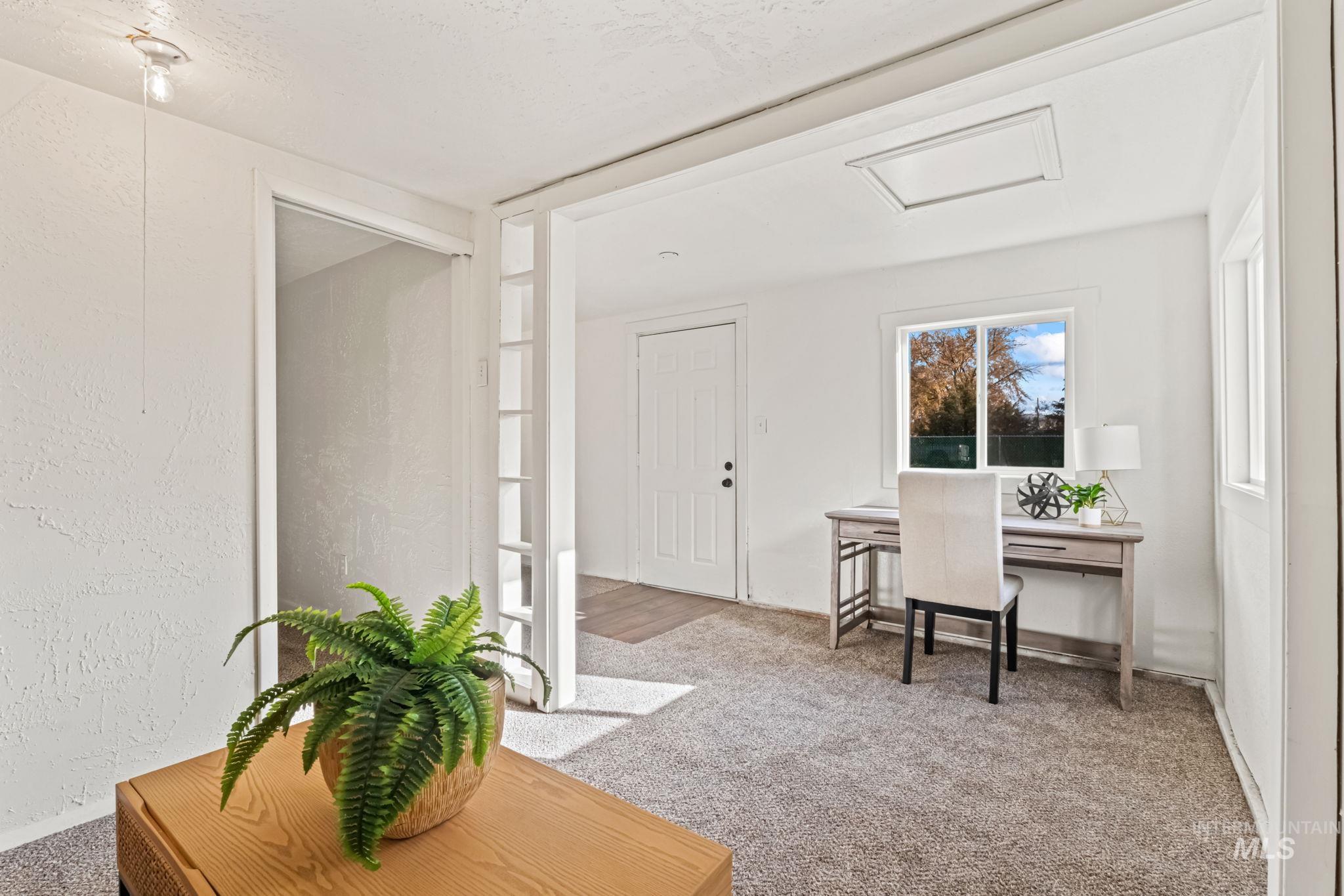 Home office featuring light colored carpet and a textured wall