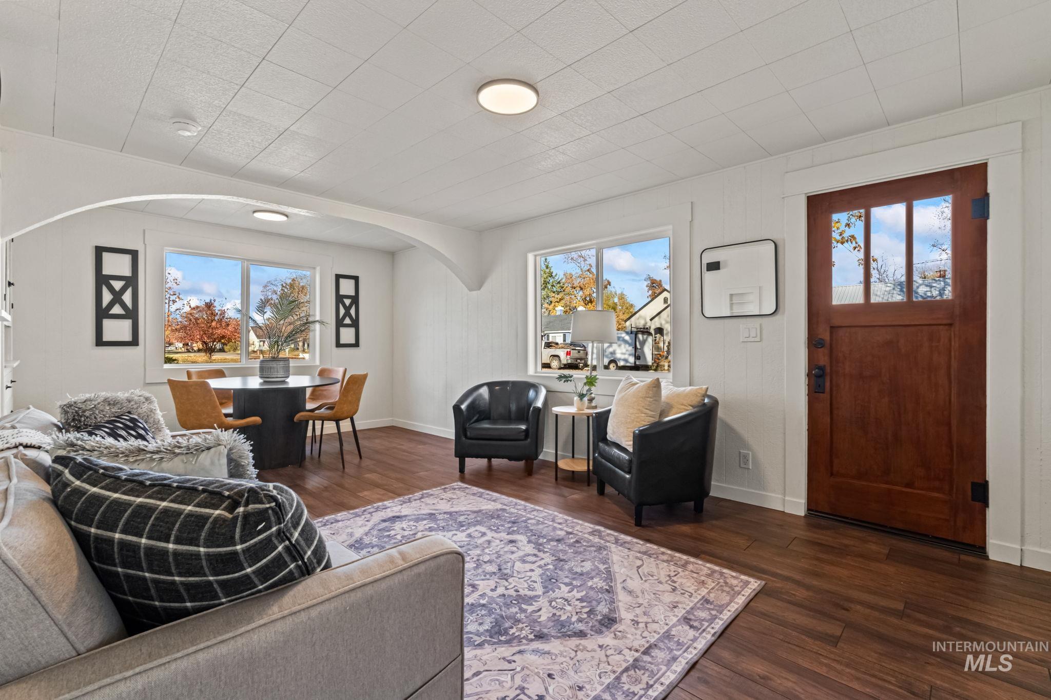 Living room featuring dark wood-style floors and arched walkways