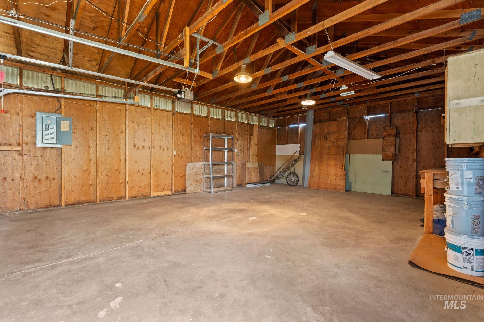Garage featuring electric panel and wooden walls