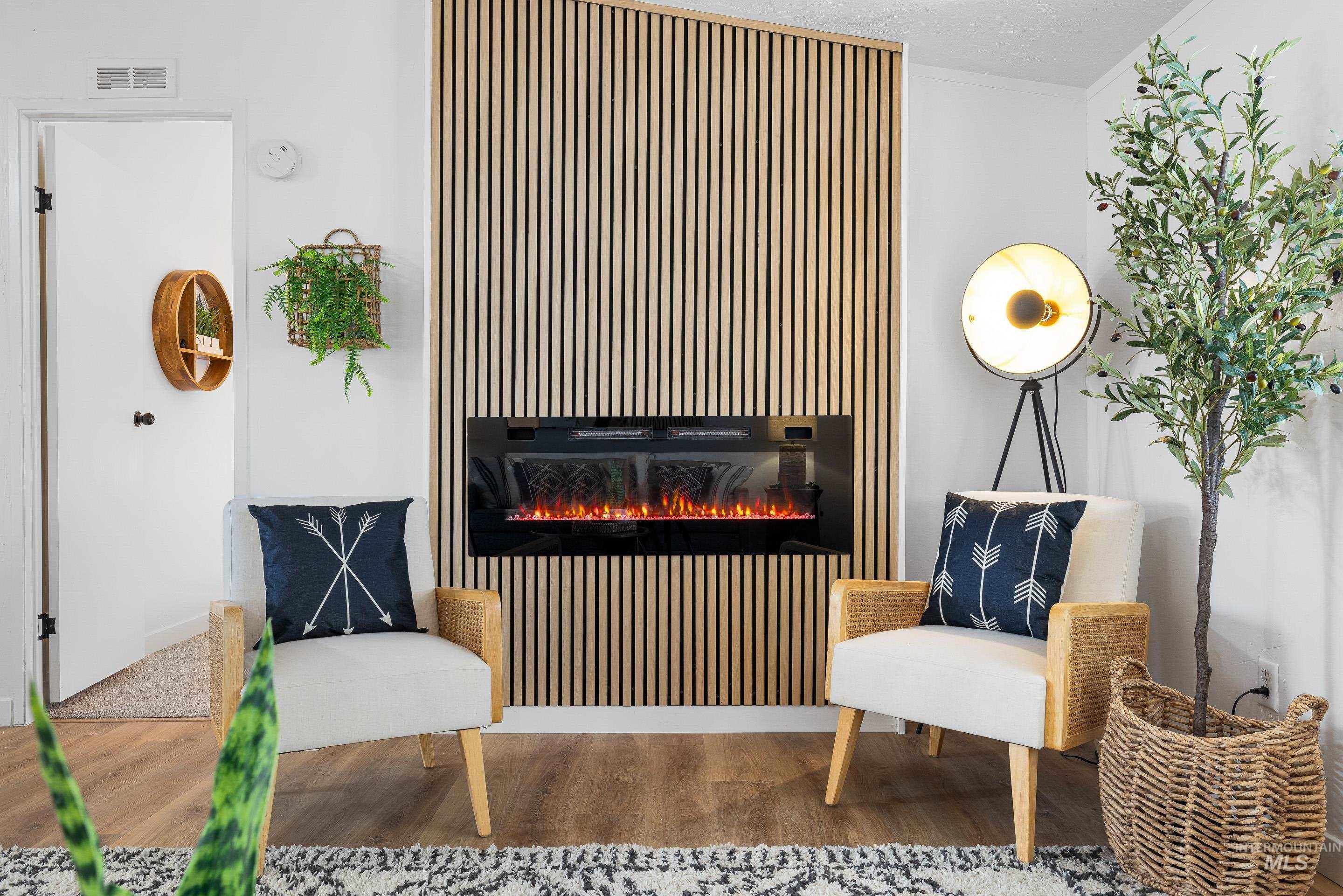 Living area featuring wood finished floors and a lit fireplace