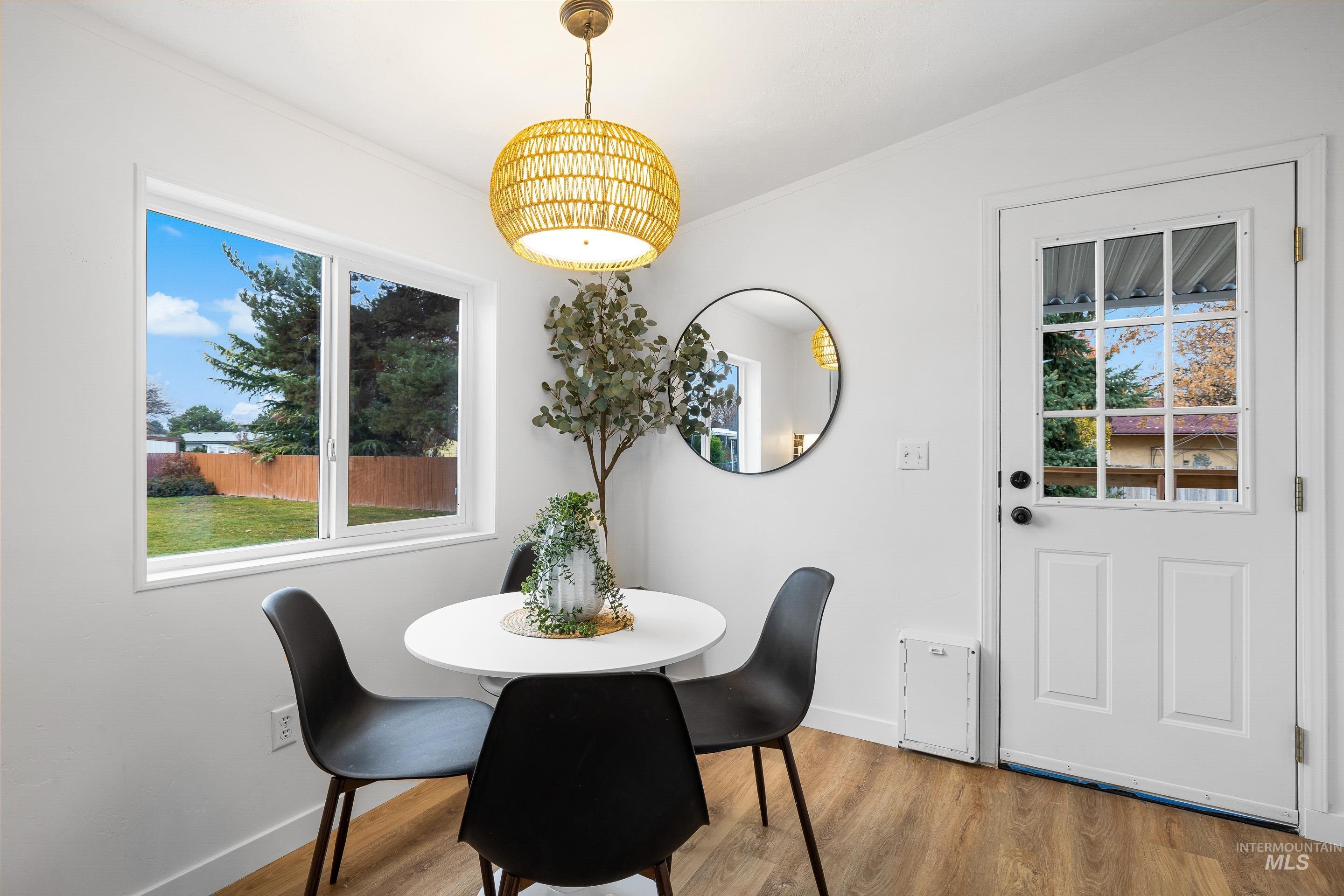 Dining space featuring wood finished floors and crown molding
