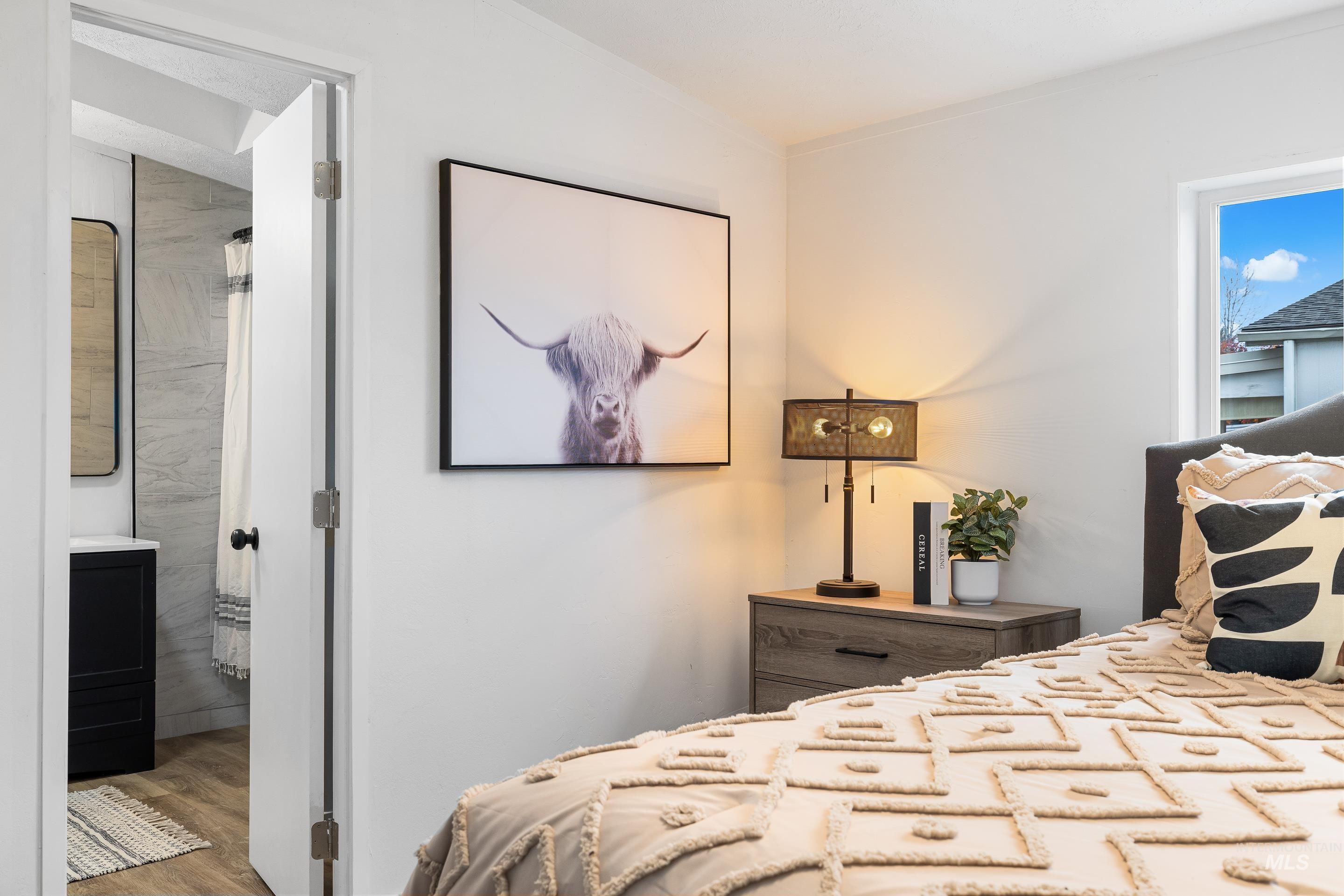 Bedroom featuring wood finished floors and ensuite bath
