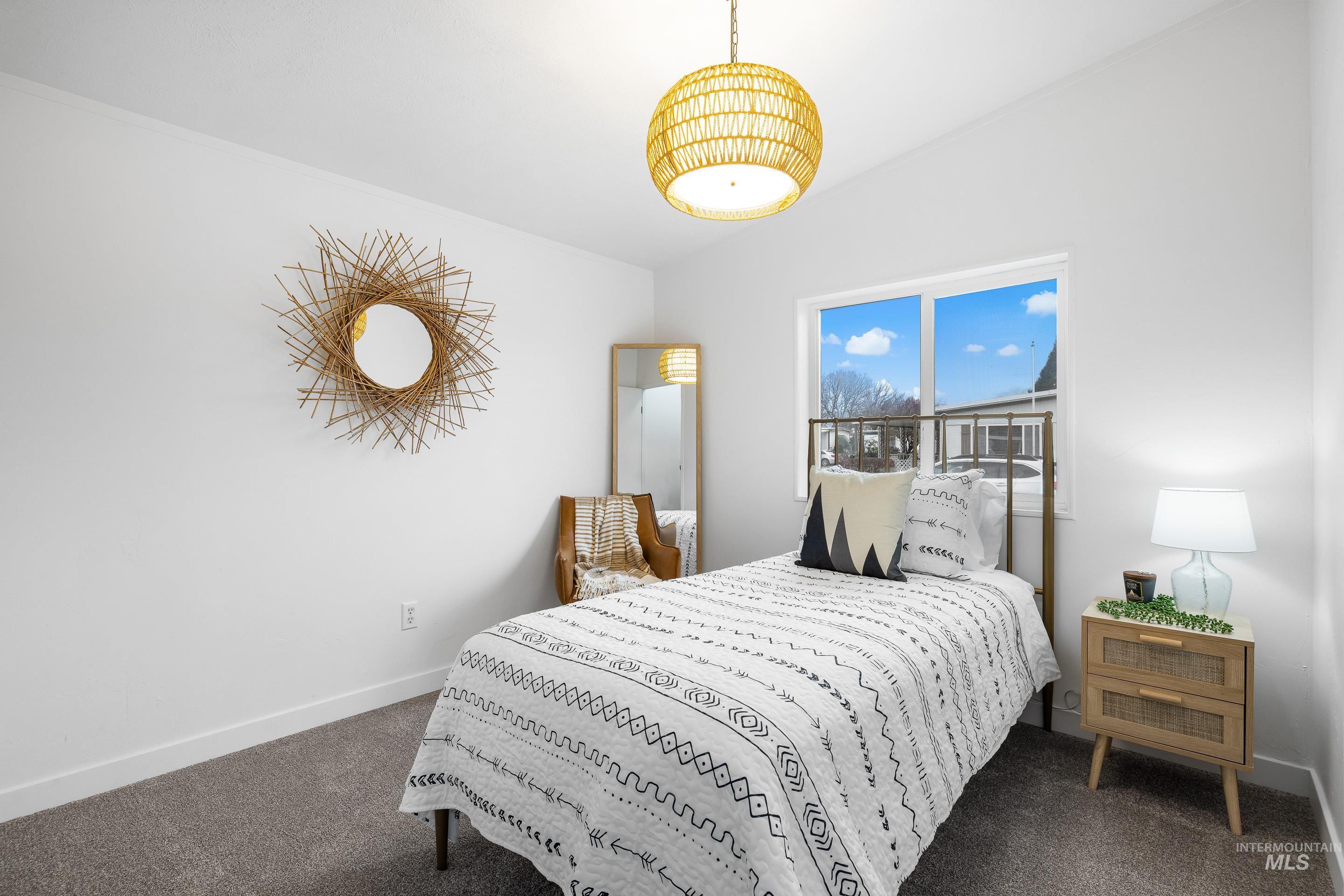 Bedroom featuring baseboards and dark carpet
