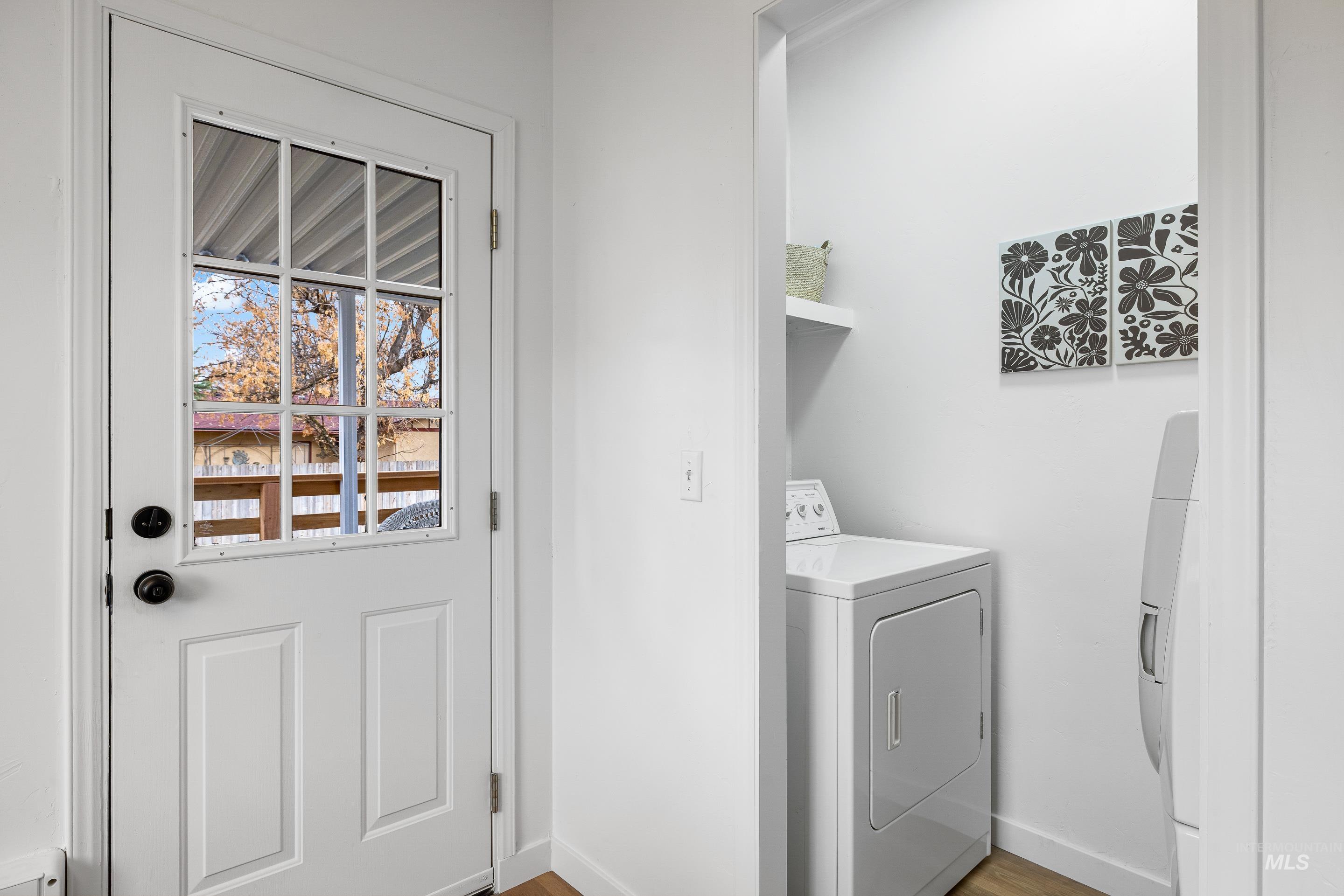 Laundry area with light wood finished floors and washing machine and dryer