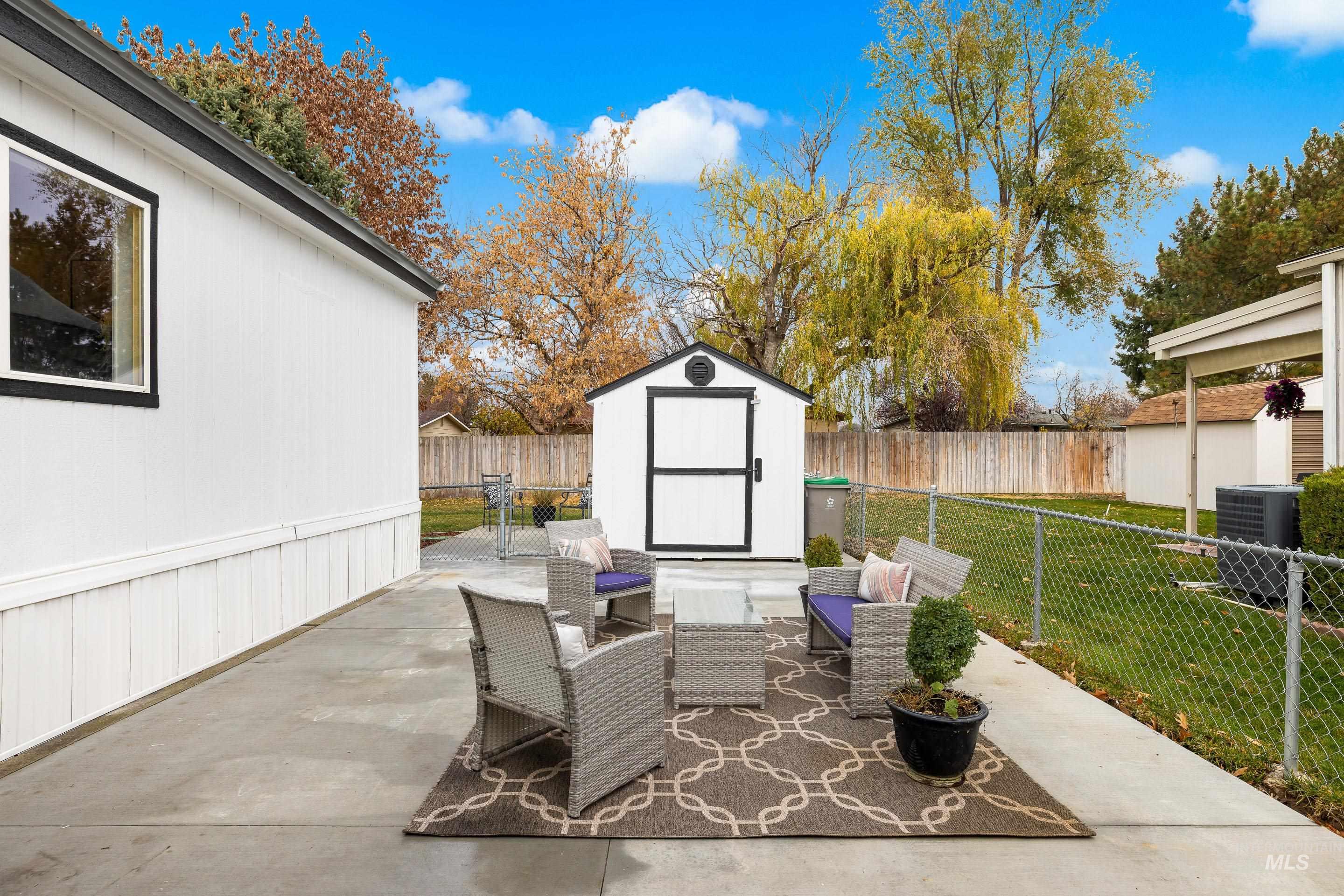 Fenced backyard with a storage shed, a patio area, and an outdoor living space