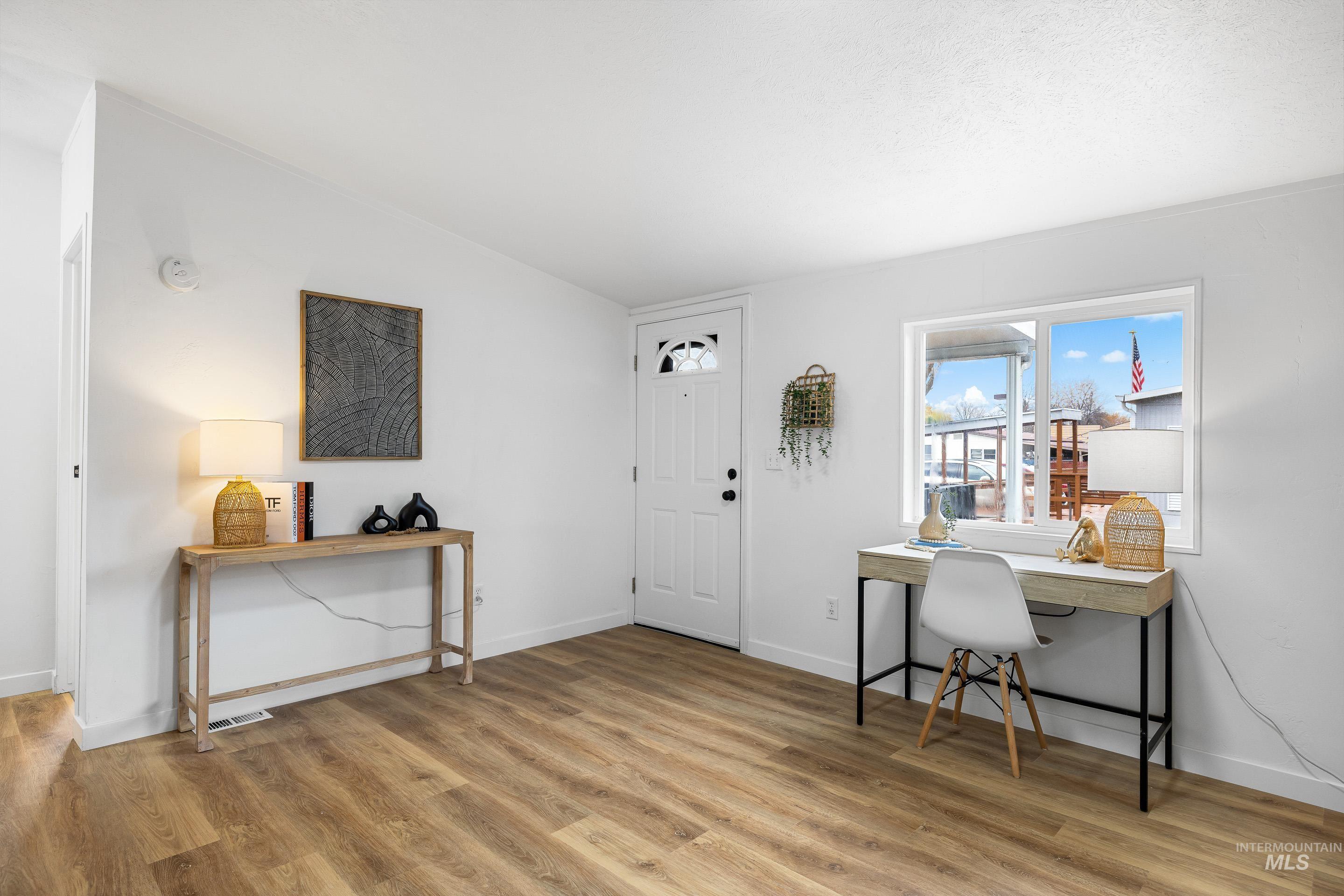 Office area featuring light wood-style floors and baseboards