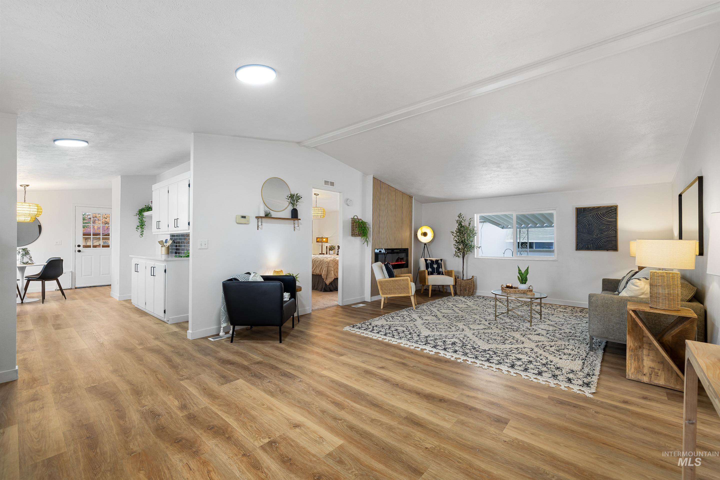 Living area featuring light wood-style floors and vaulted ceiling