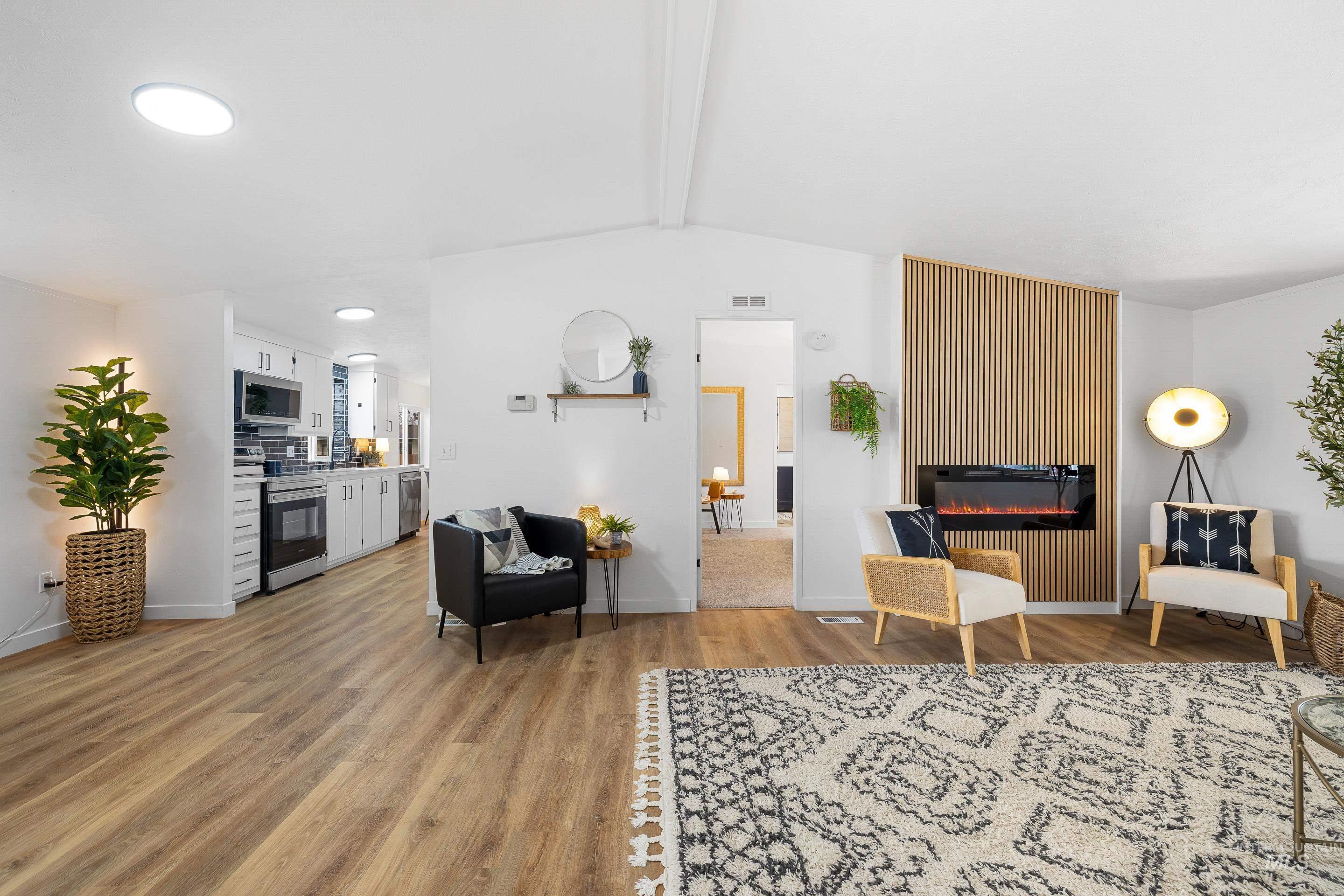 Living room with light wood-style flooring and a glass covered fireplace