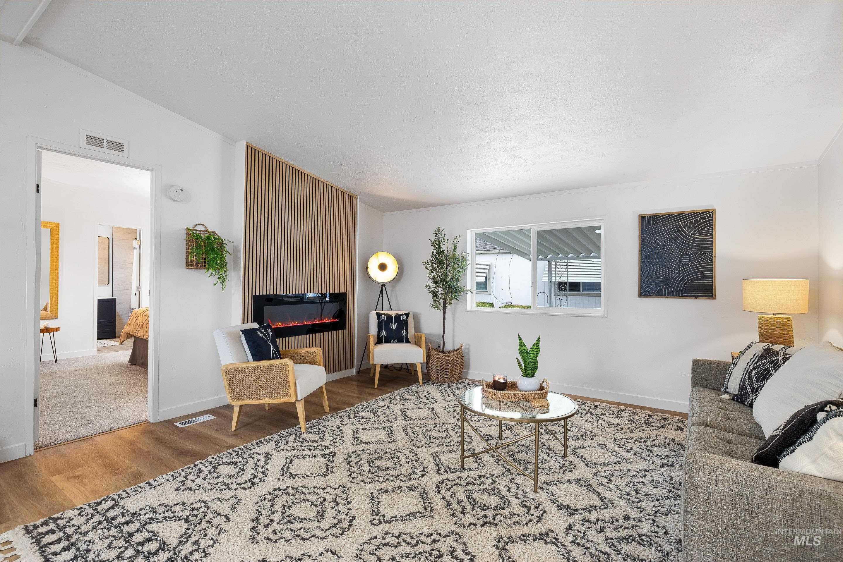 Living area with wood finished floors, a fireplace, and lofted ceiling