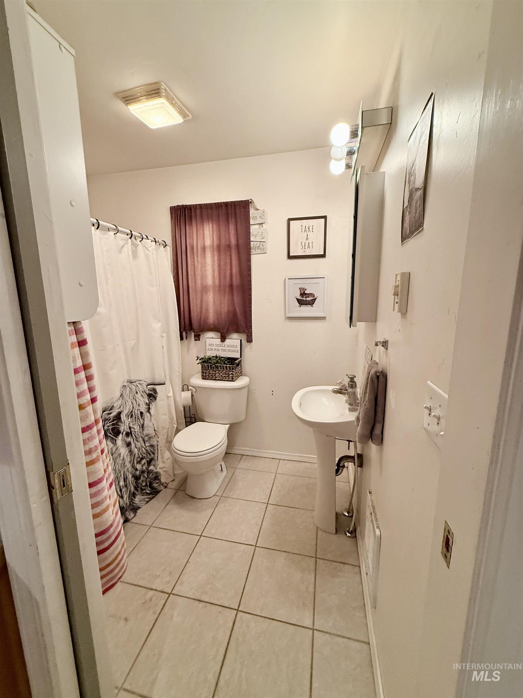 Full bathroom featuring light tile patterned flooring and a shower with shower curtain