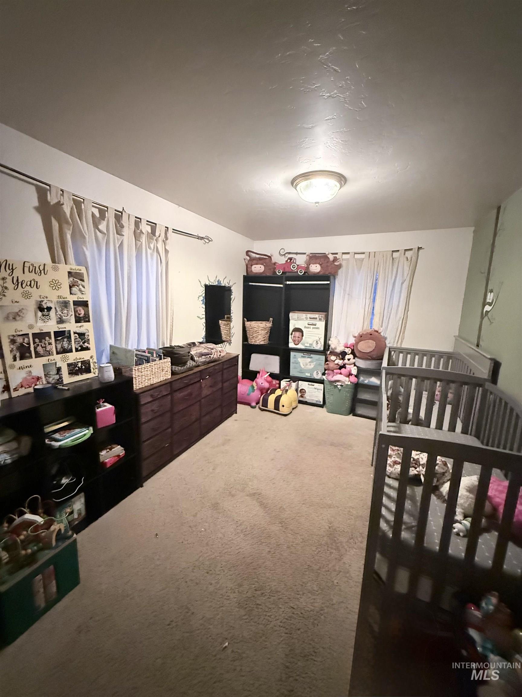 Bedroom with carpet flooring and a crib