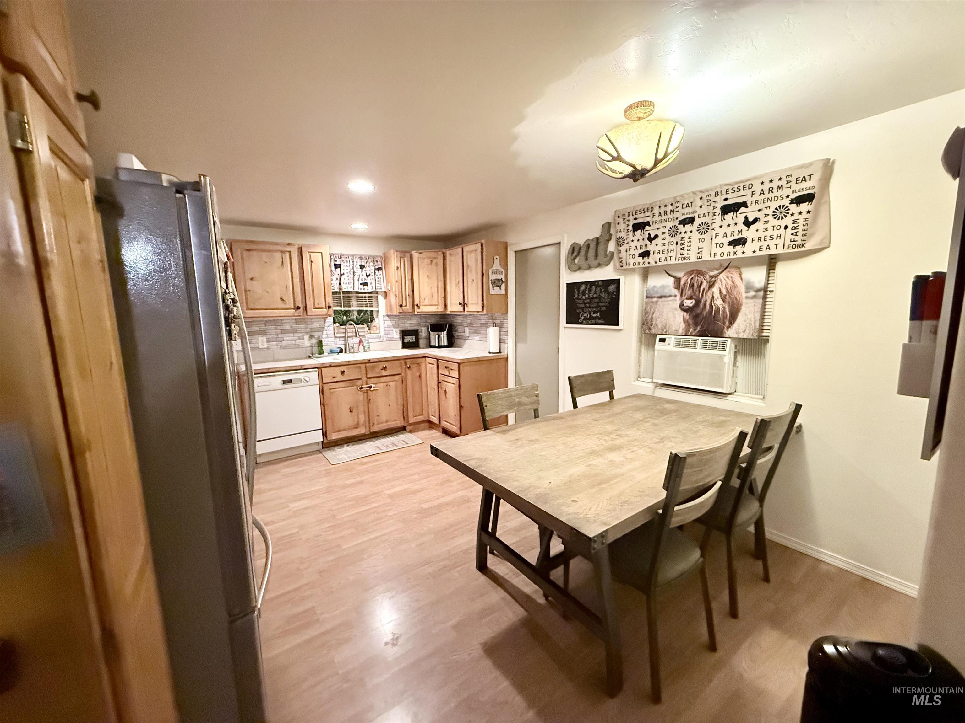 Dining space with light wood finished floors, recessed lighting, and cooling unit