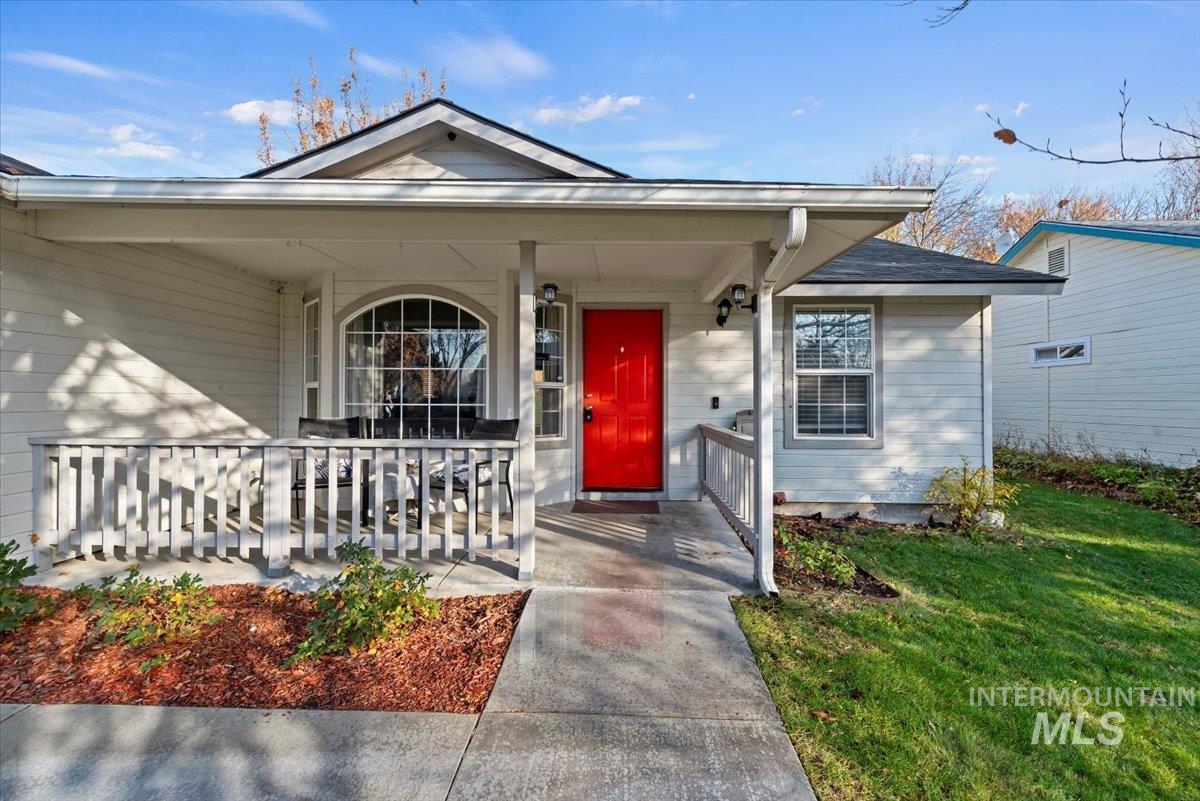 Doorway to property featuring a porch and a lawn