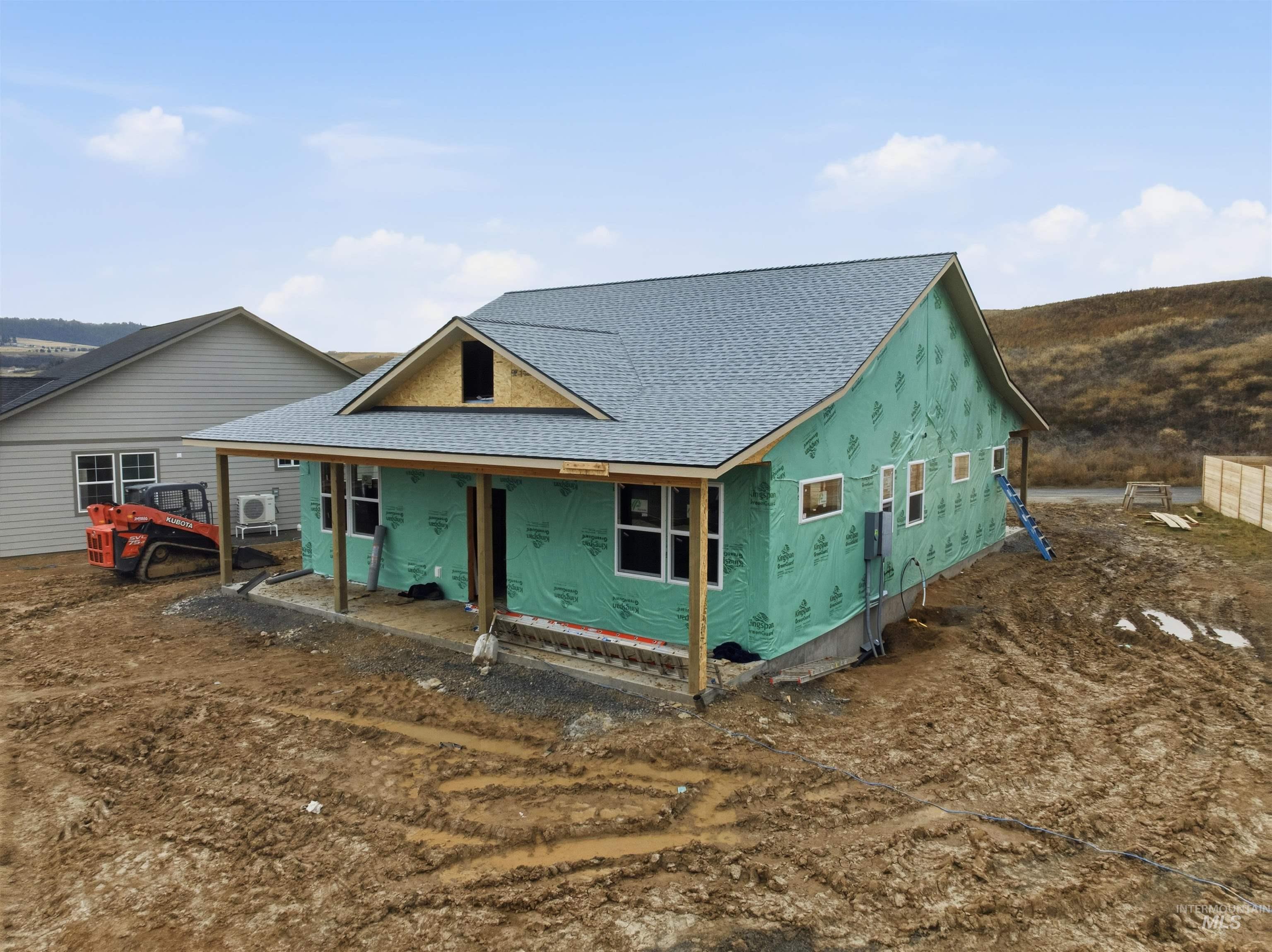 Rear view of house featuring a shingled roof and covered porch