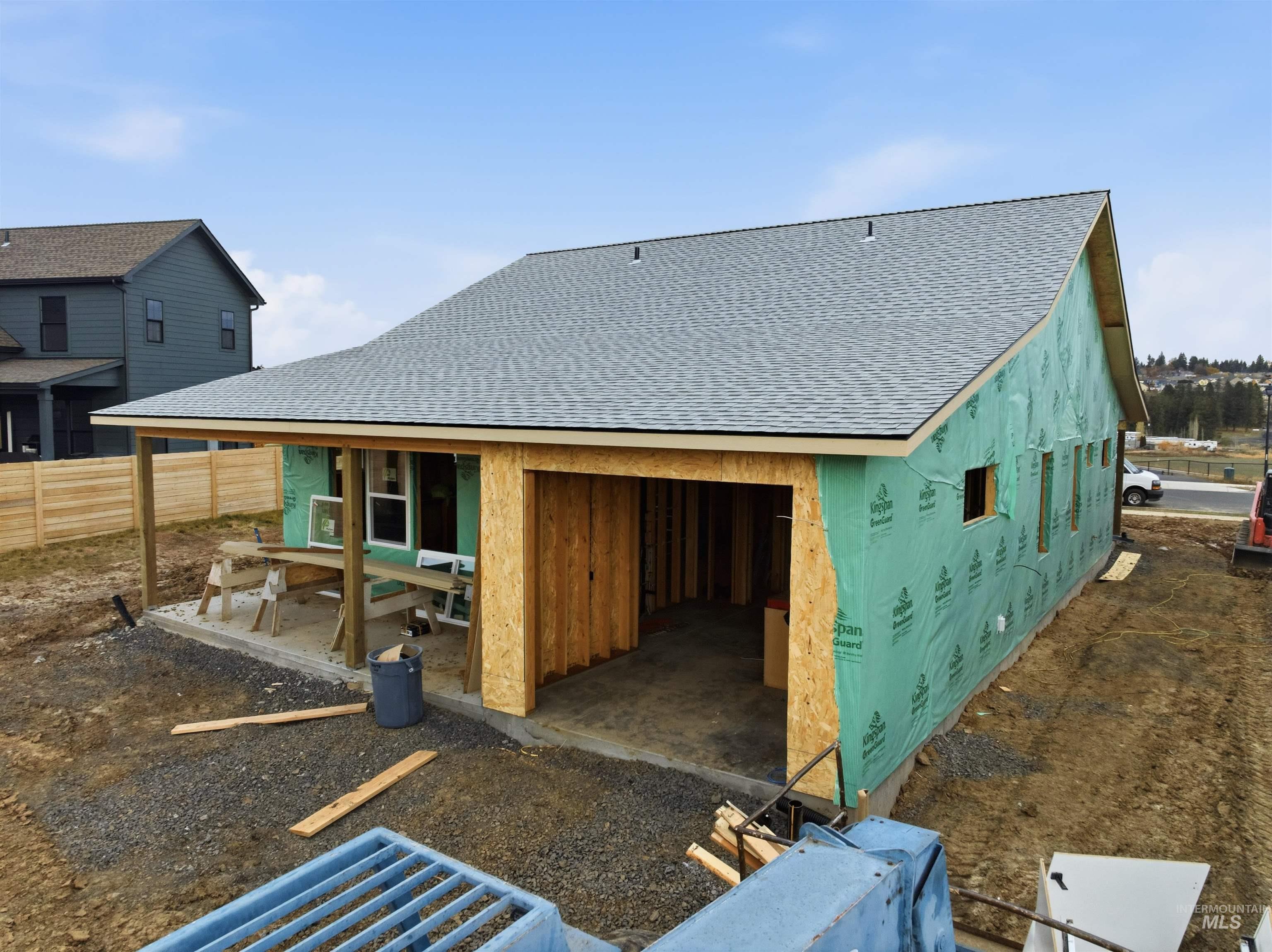 Rear view of house featuring roof with shingles and a patio