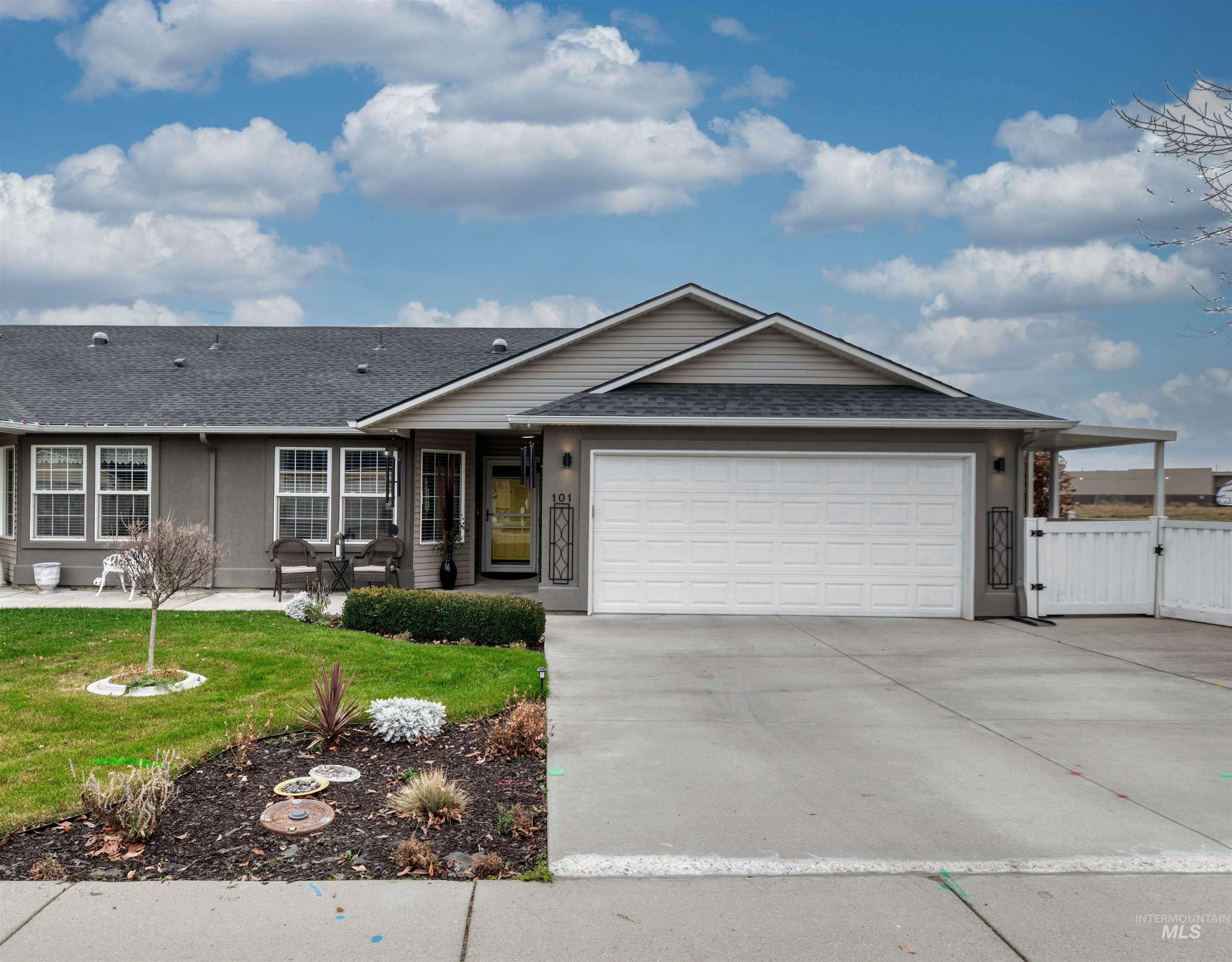Ranch-style house featuring a shingled roof, a gate, concrete driveway, and a garage