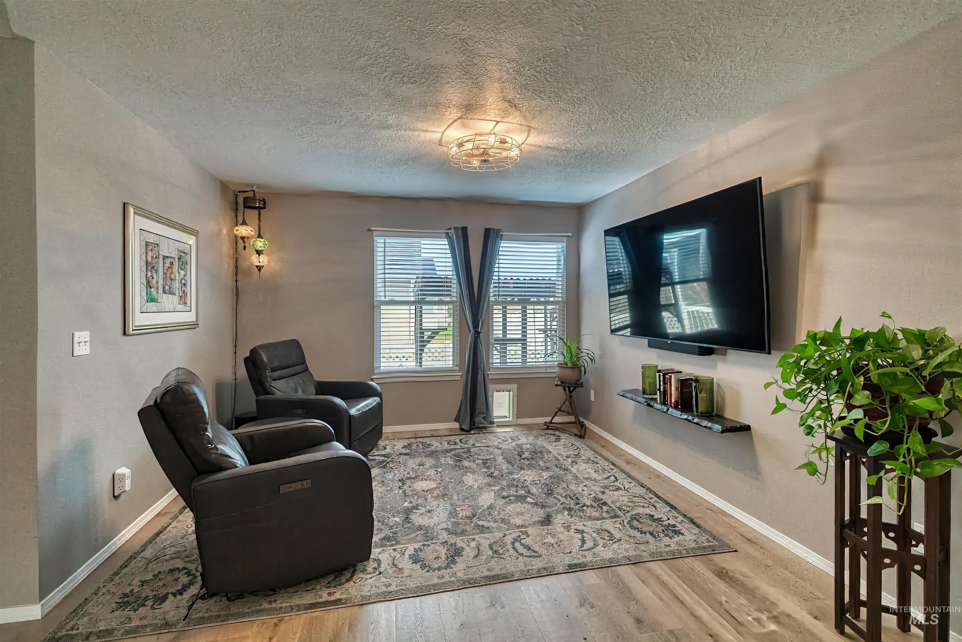 Living area with a textured ceiling and wood finished floors