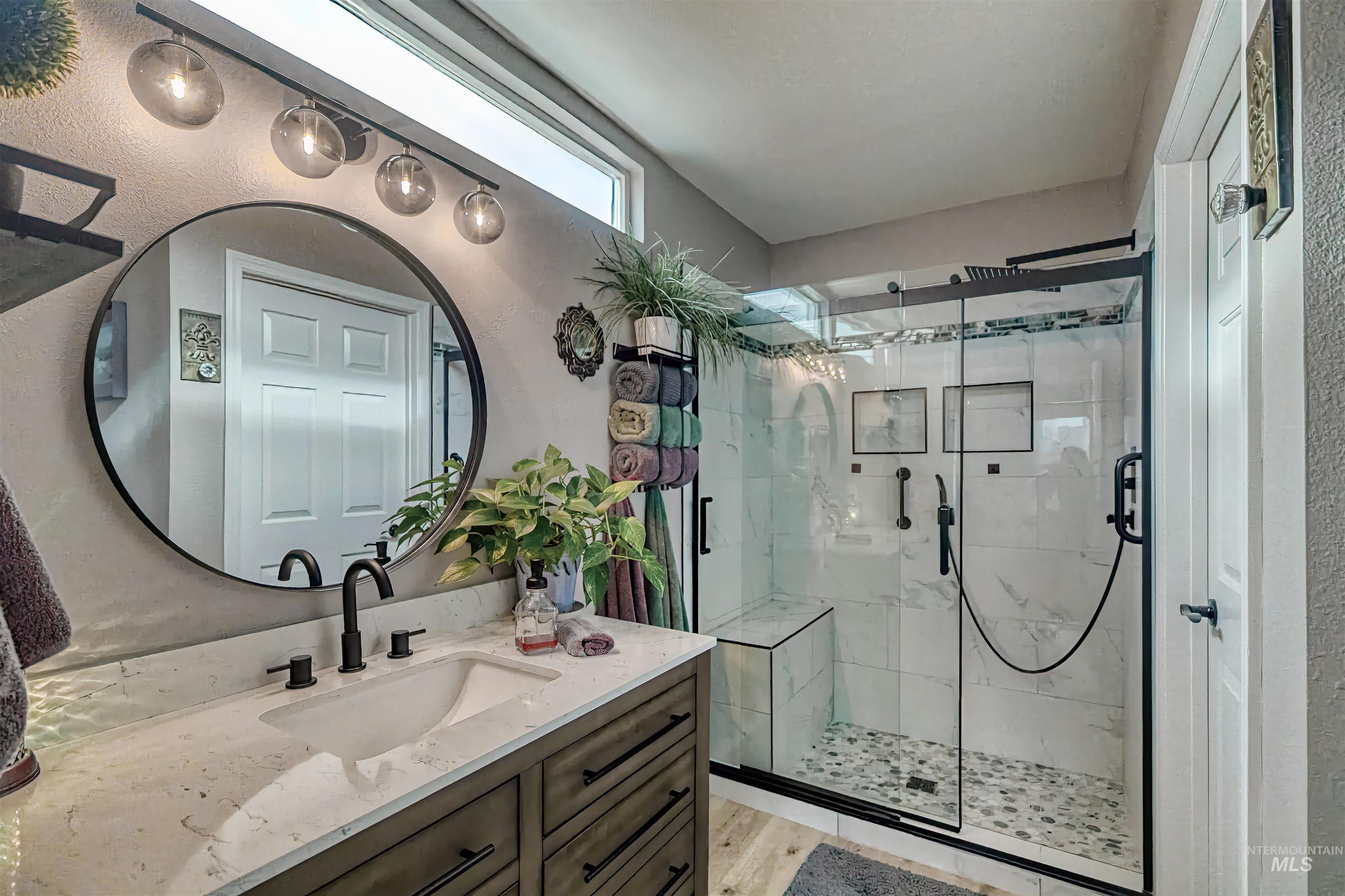Bathroom with vanity, a stall shower, and a textured wall