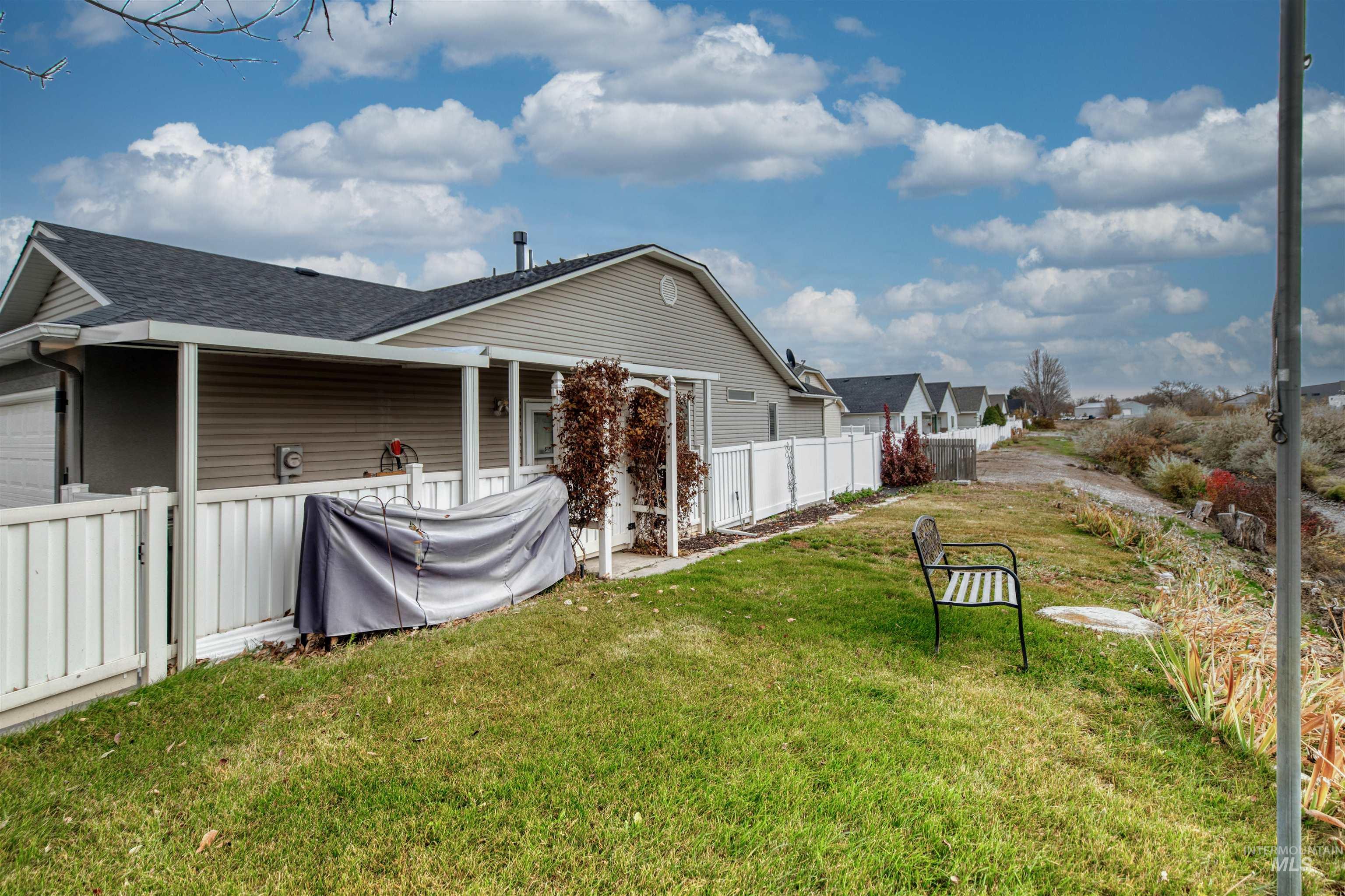Rear view of property with roof with shingles, a patio area, and a garage