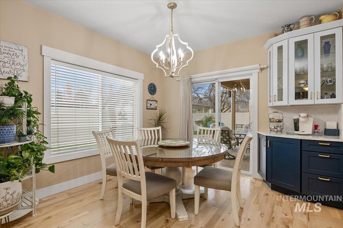 Dining space with light wood finished floors and a chandelier
