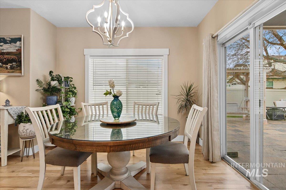 Dining area featuring light wood-style floors, healthy amount of natural light, and a chandelier