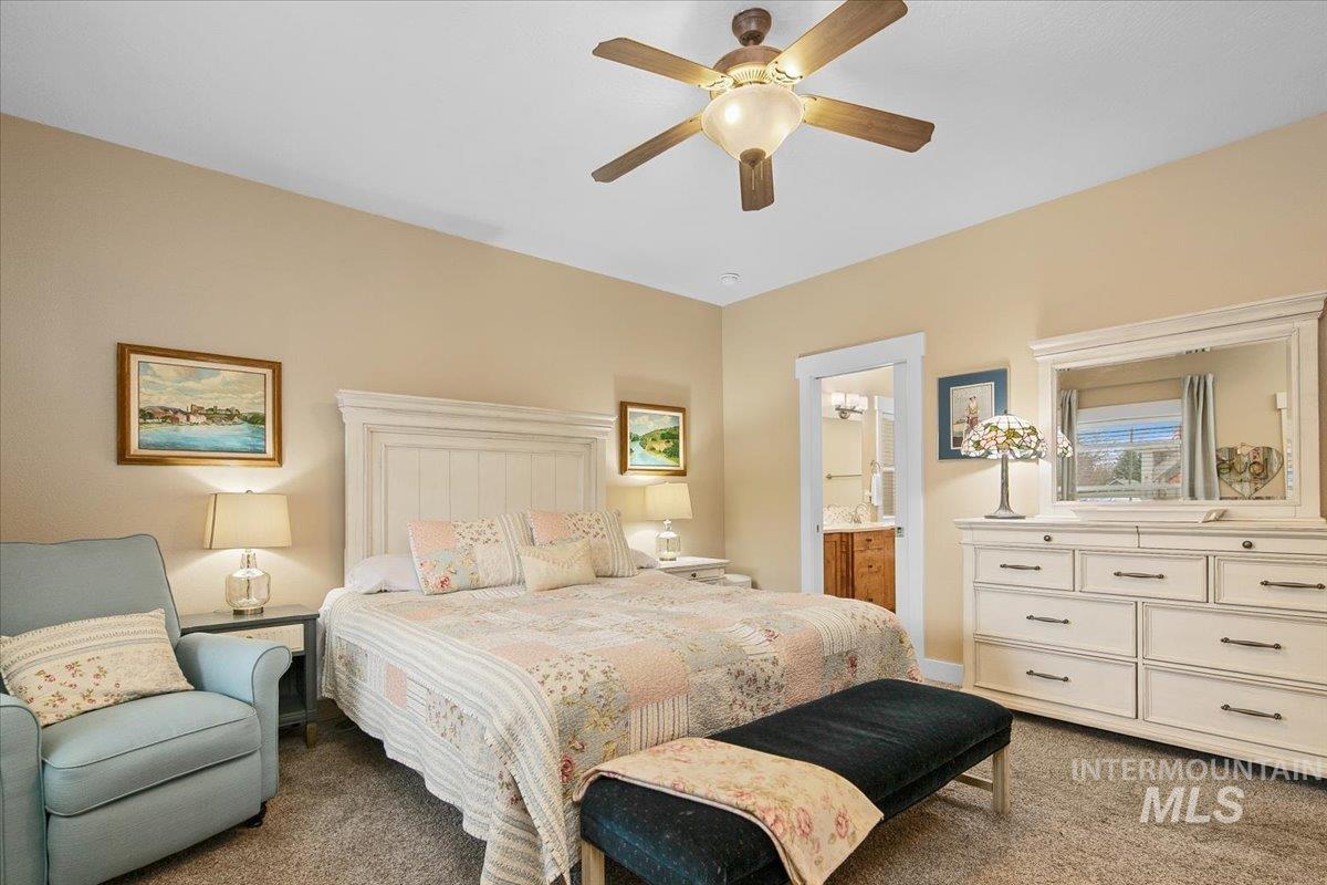Bedroom featuring carpet flooring, a ceiling fan, and connected bathroom