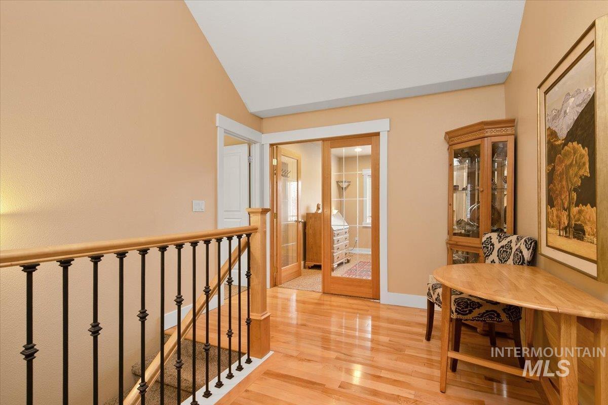 Hallway featuring light wood finished floors and an upstairs landing