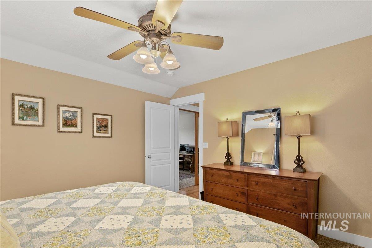 Bedroom featuring a ceiling fan and vaulted ceiling