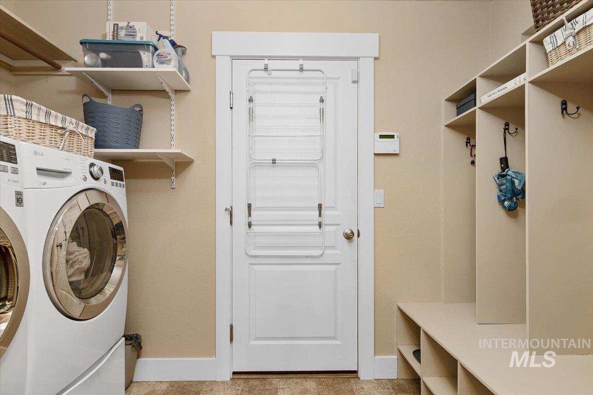Laundry area with washer and clothes dryer and light tile patterned flooring