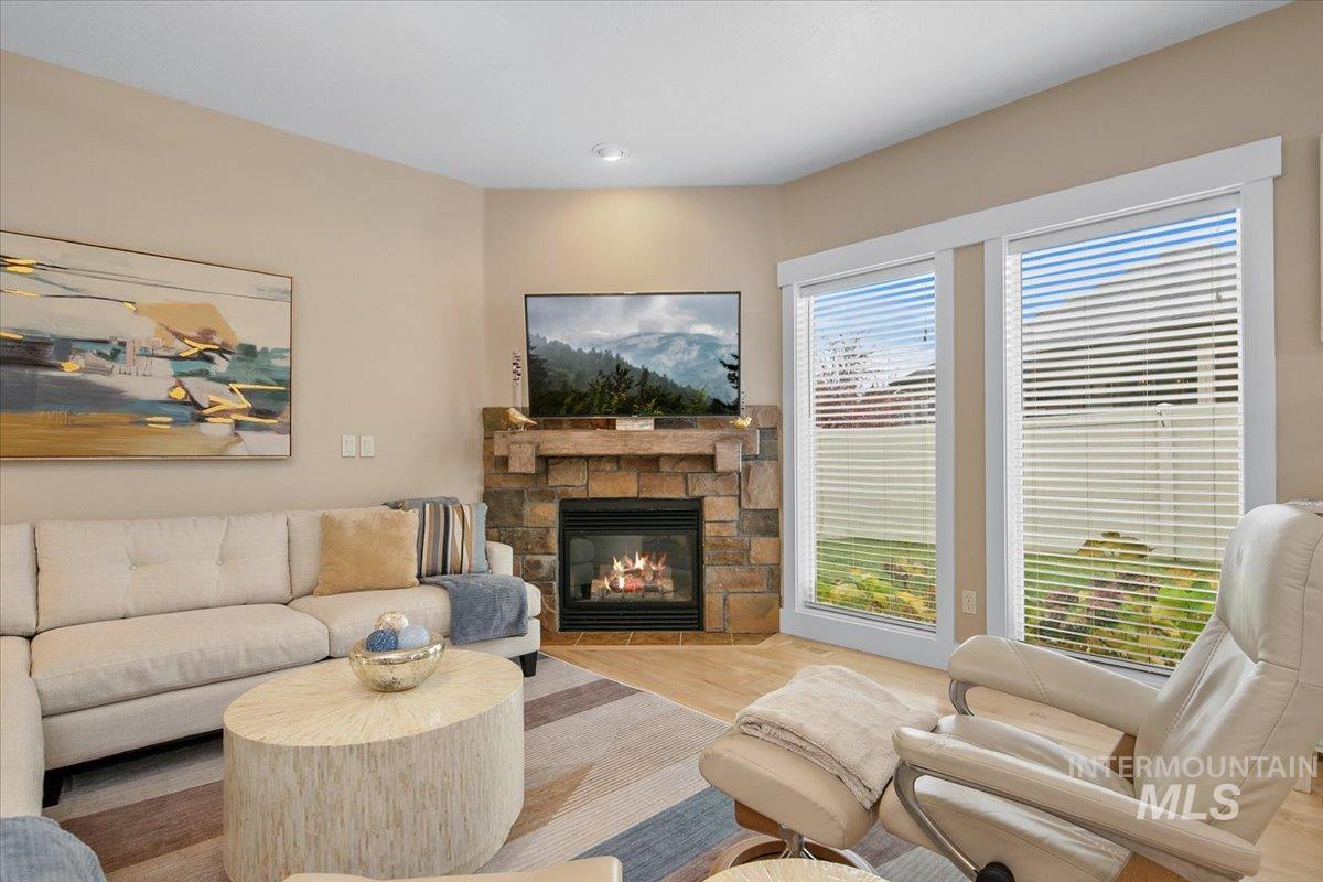 Living area featuring a stone fireplace and wood finished floors