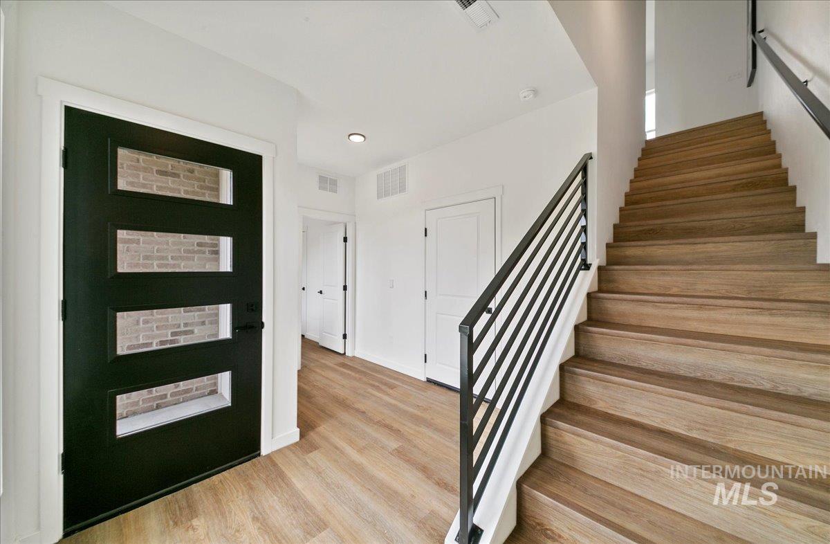 Entryway featuring stairs, light wood-style flooring, and recessed lighting