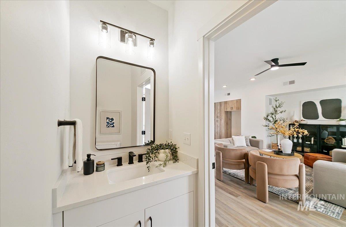 Bathroom featuring ceiling fan, light wood-style floors, and vanity