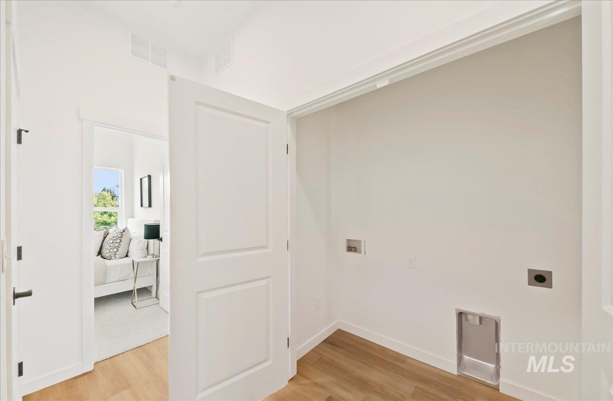 Laundry room featuring light wood-style flooring, washer hookup, and electric dryer hookup