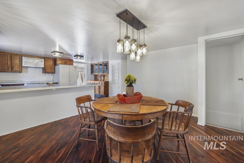 Dining area with dark wood-style flooring and a chandelier