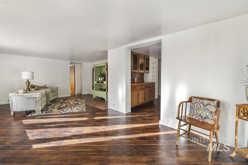 Living area with dark wood-style floors and baseboards