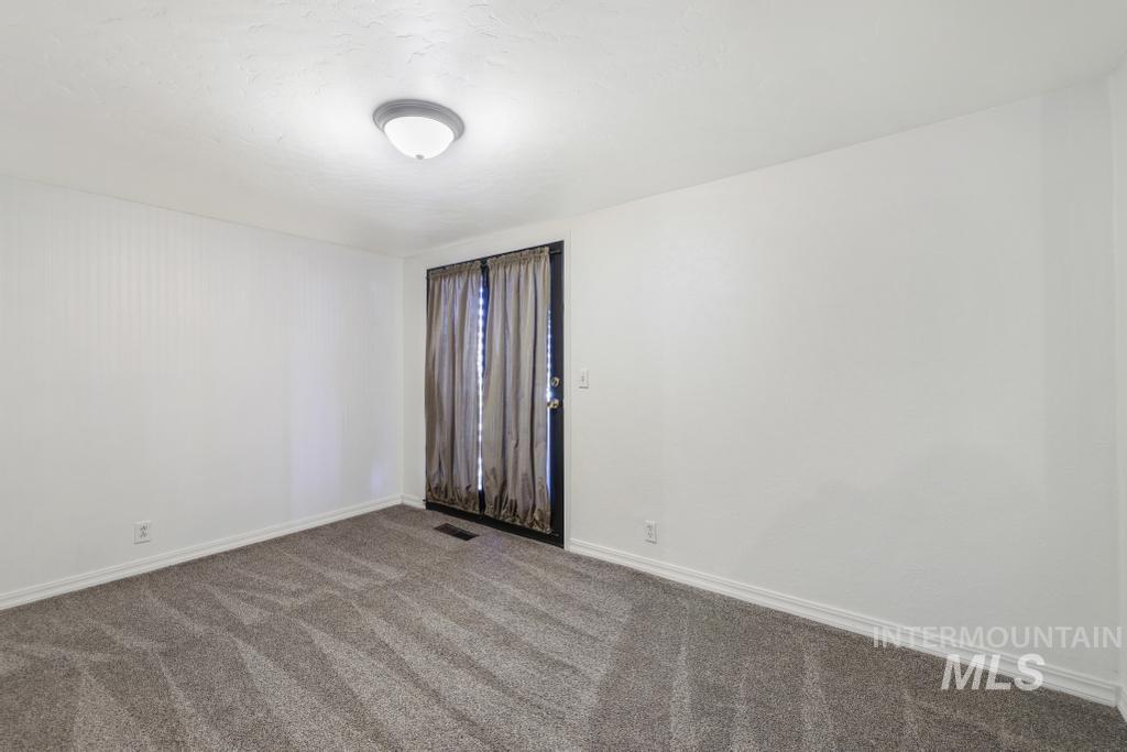 Empty room featuring baseboards and carpet