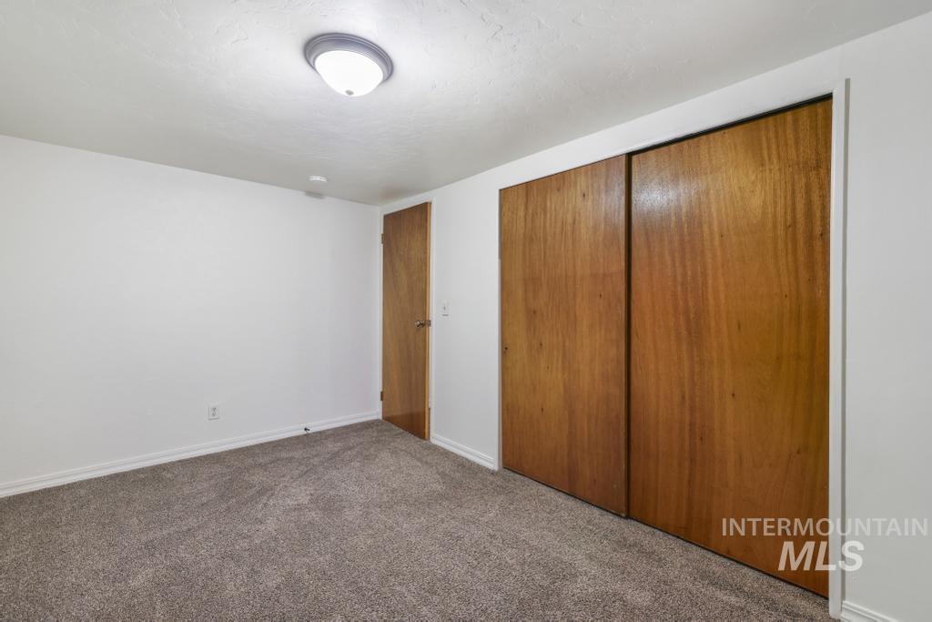 Unfurnished bedroom featuring a closet, carpet floors, and a textured ceiling