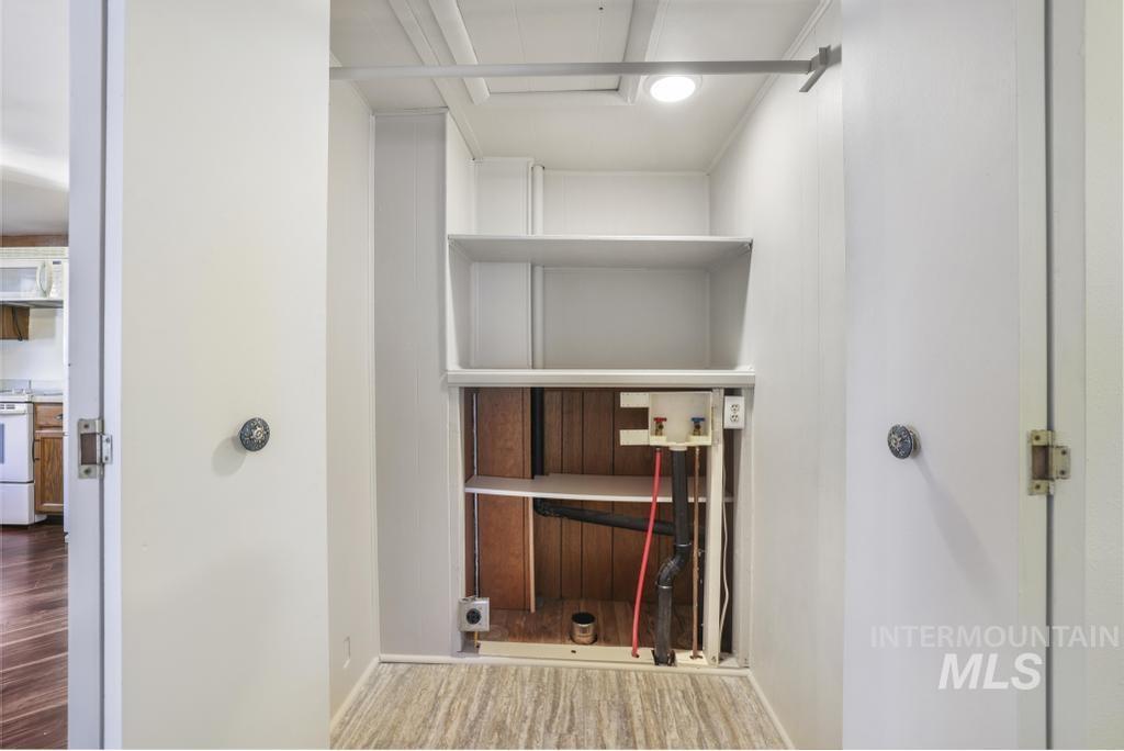 Laundry area with wood finished floors and washer hookup