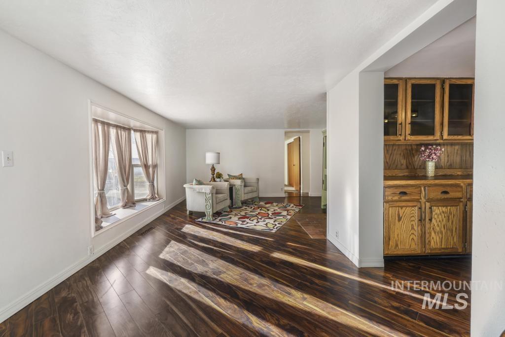 Living area featuring dark wood-style floors and baseboards