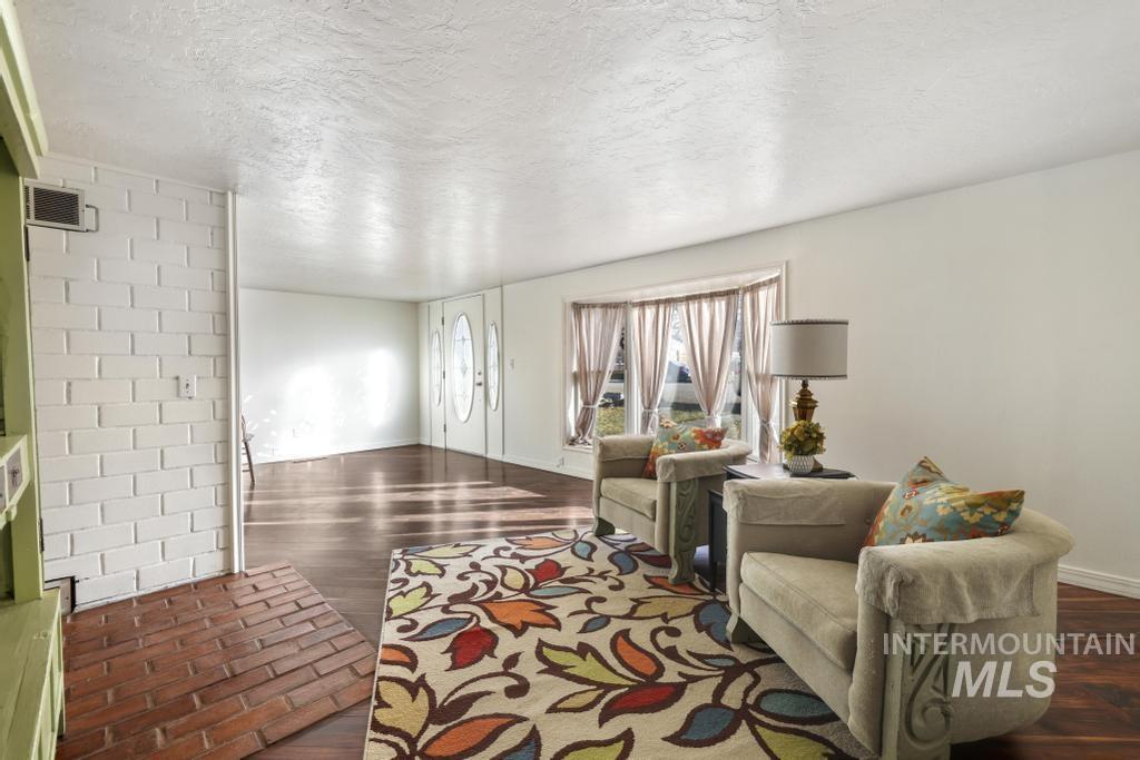 Living area with a textured ceiling and dark wood-style floors