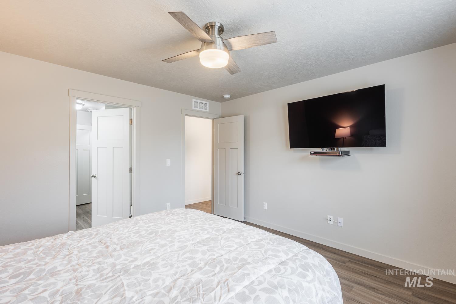 Bedroom featuring wood finished floors, a ceiling fan, and a textured ceiling