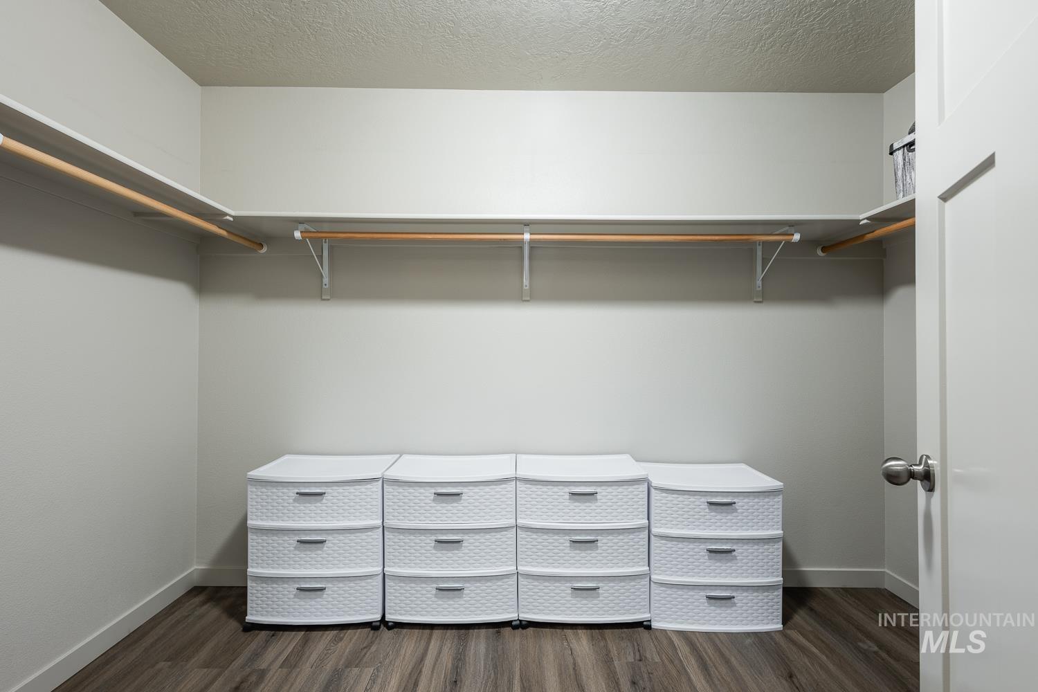 Walk in closet featuring dark wood-style flooring