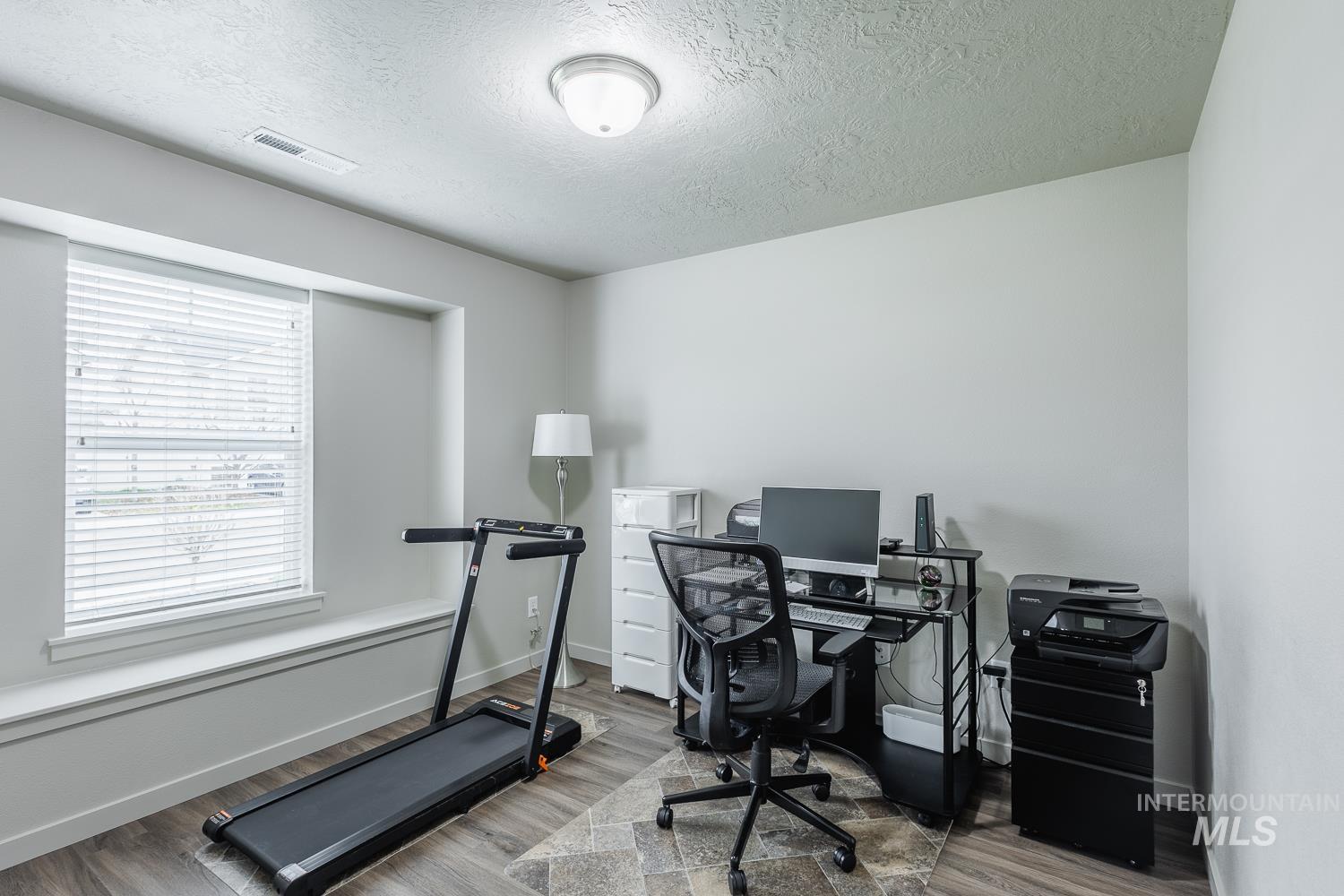 Office area featuring a textured ceiling and wood finished floors