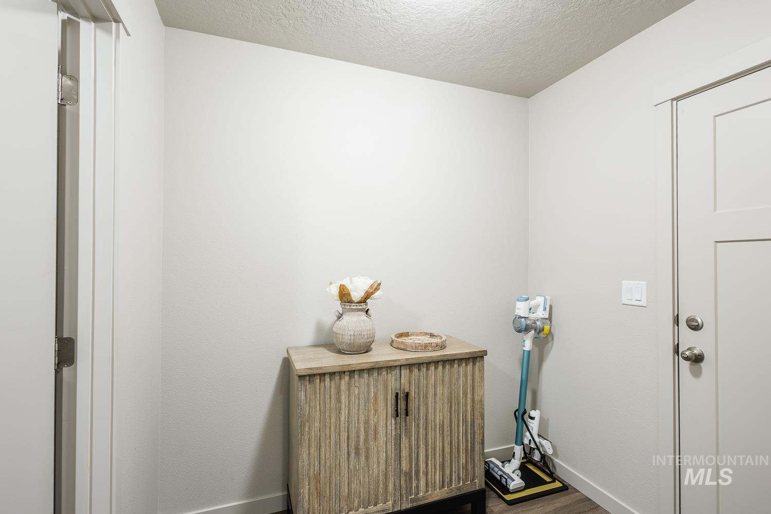 Washroom with a textured ceiling and dark wood-type flooring